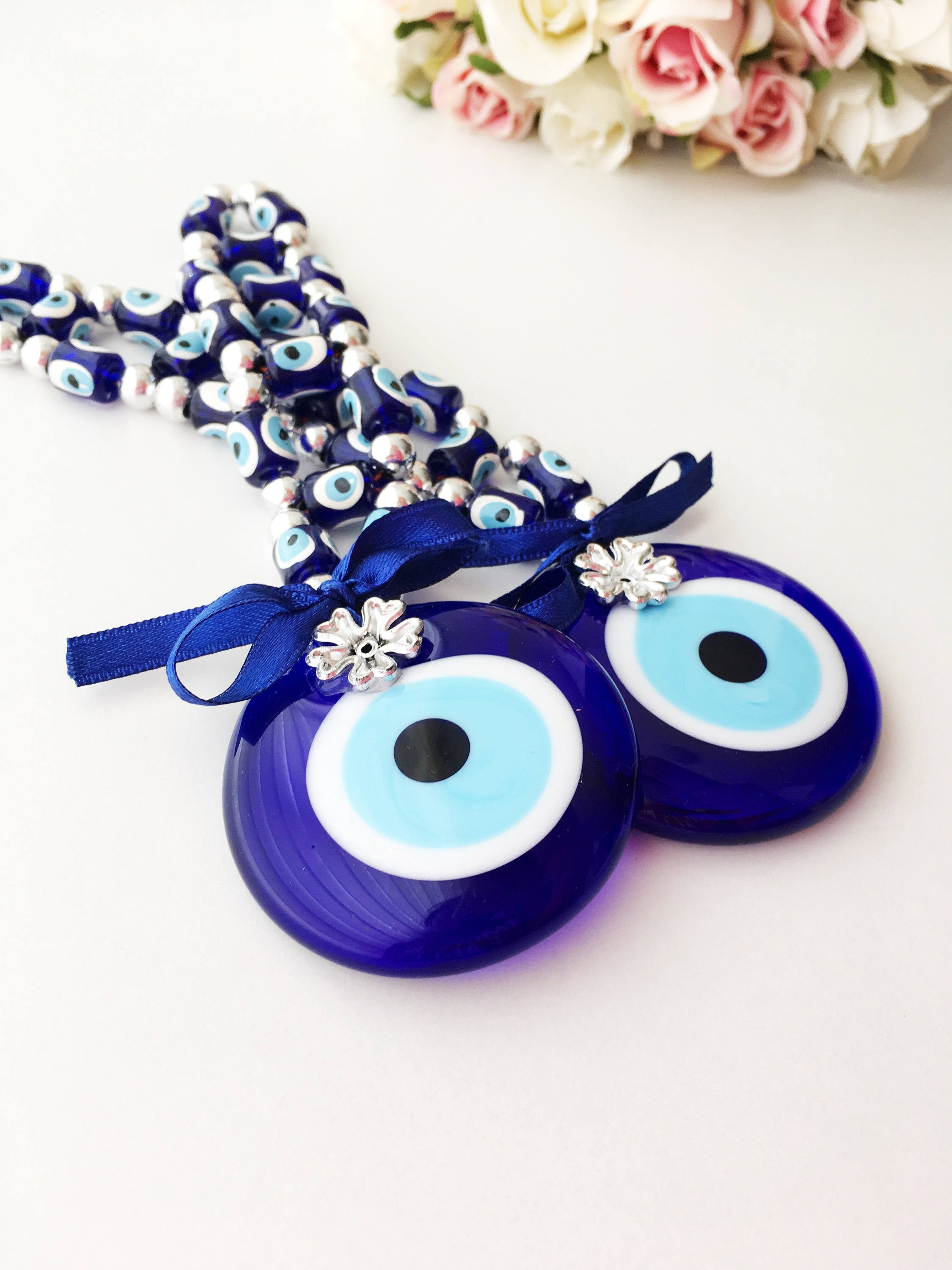 A beautifully crafted Greek Evil Eye Wall Hanging featuring large and small blue evil eye beads, symbolizing protection and good luck.