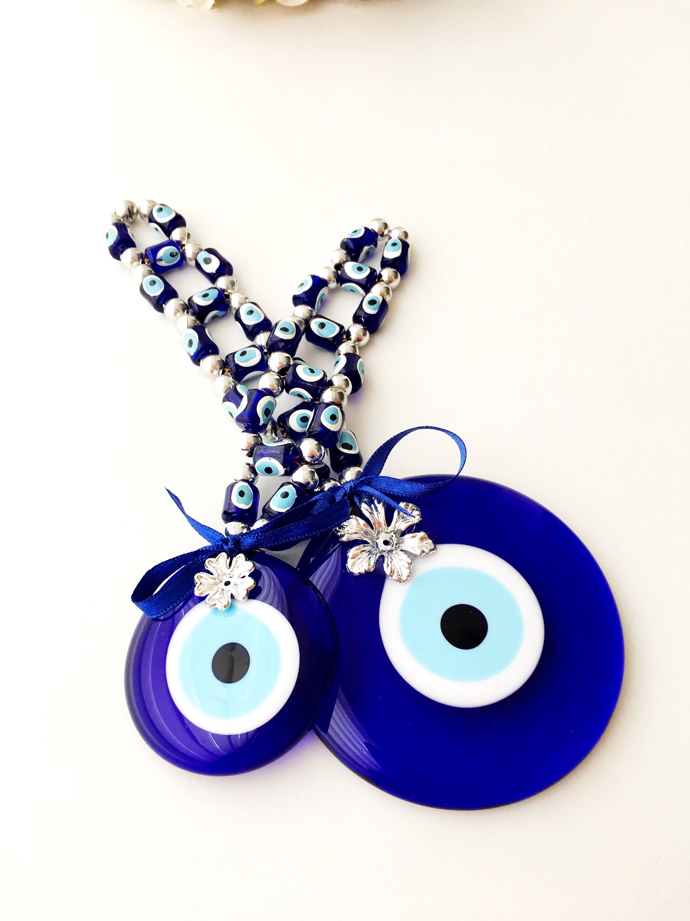 A beautifully crafted Greek Evil Eye Wall Hanging featuring large and small blue evil eye beads, symbolizing protection and good luck.