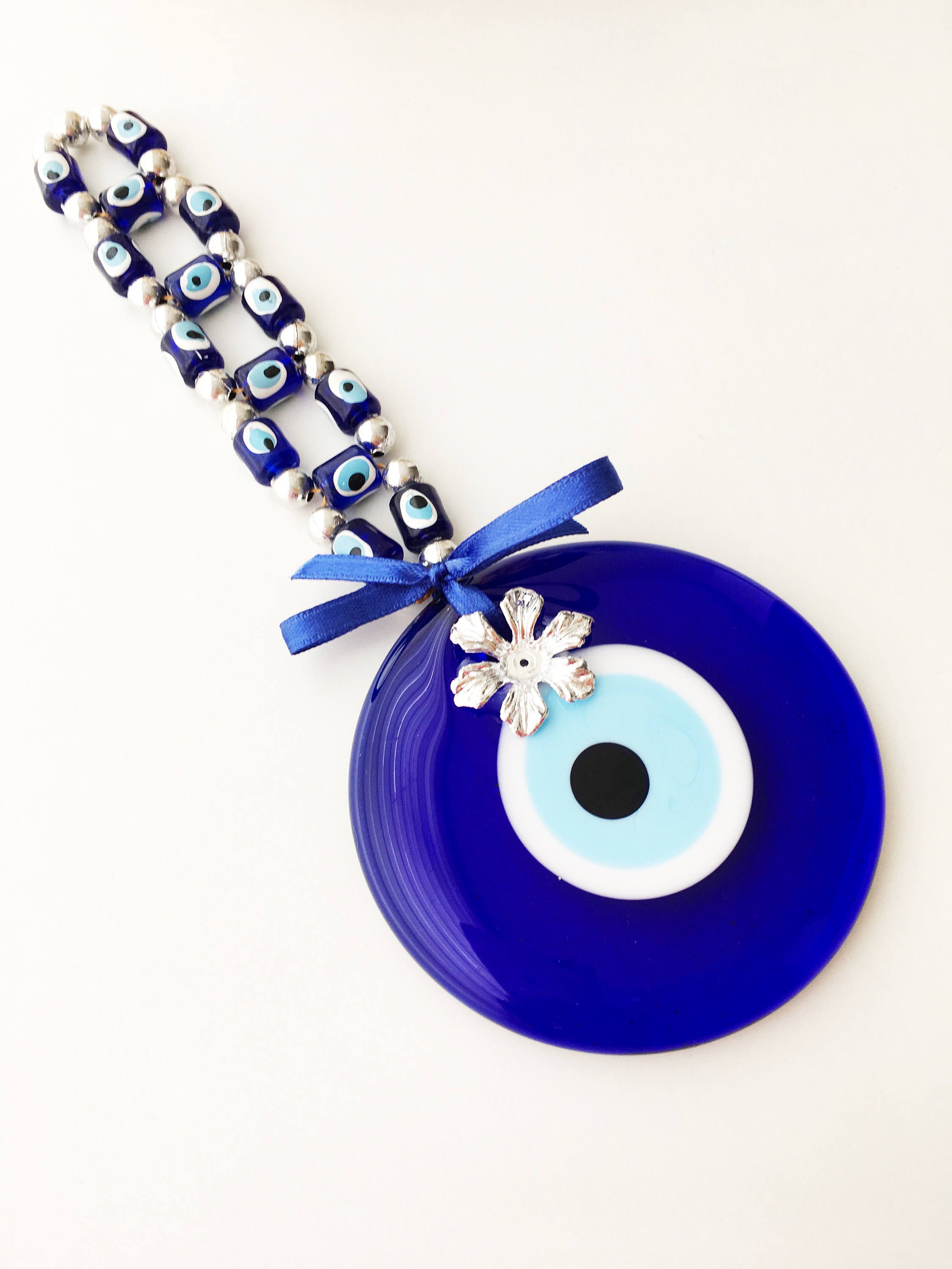 A beautifully crafted Greek Evil Eye Wall Hanging featuring large and small blue evil eye beads, symbolizing protection and good luck.