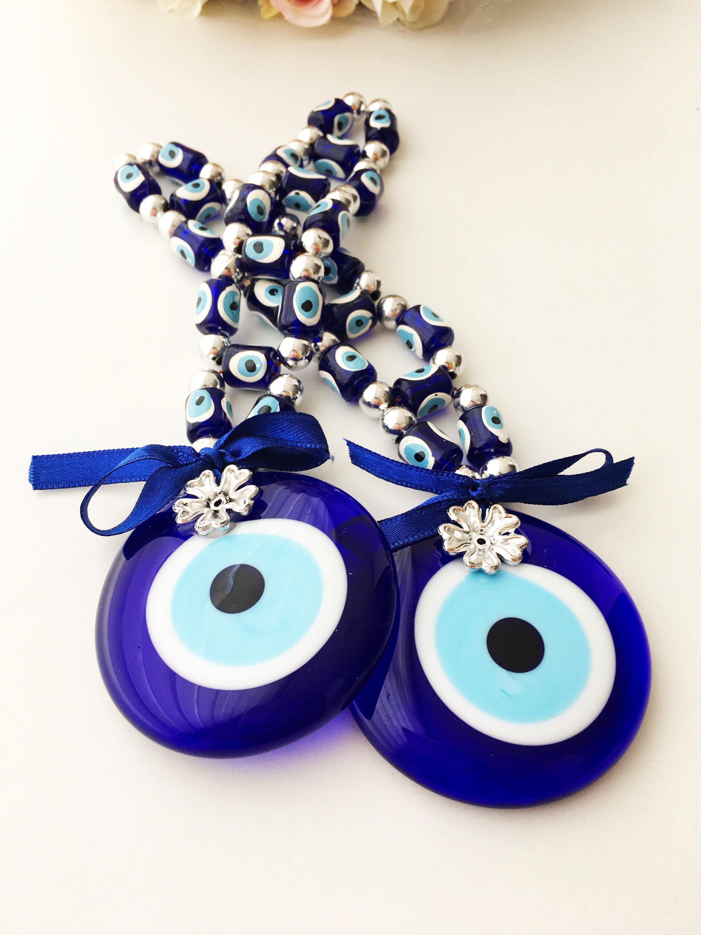 A beautifully crafted Greek Evil Eye Wall Hanging featuring large and small blue evil eye beads, symbolizing protection and good luck.