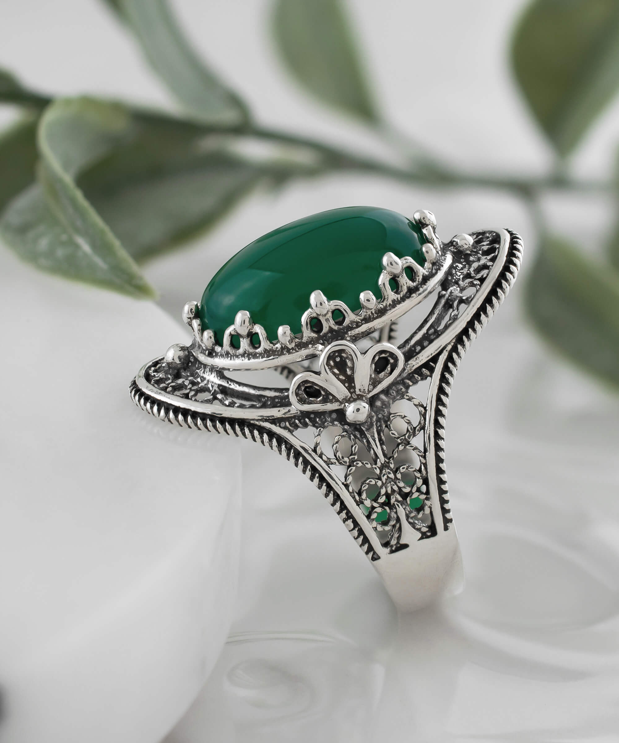 A beautiful handmade silver statement ring featuring a green agate gemstone in a filigree design, elegantly displayed in a gift box.