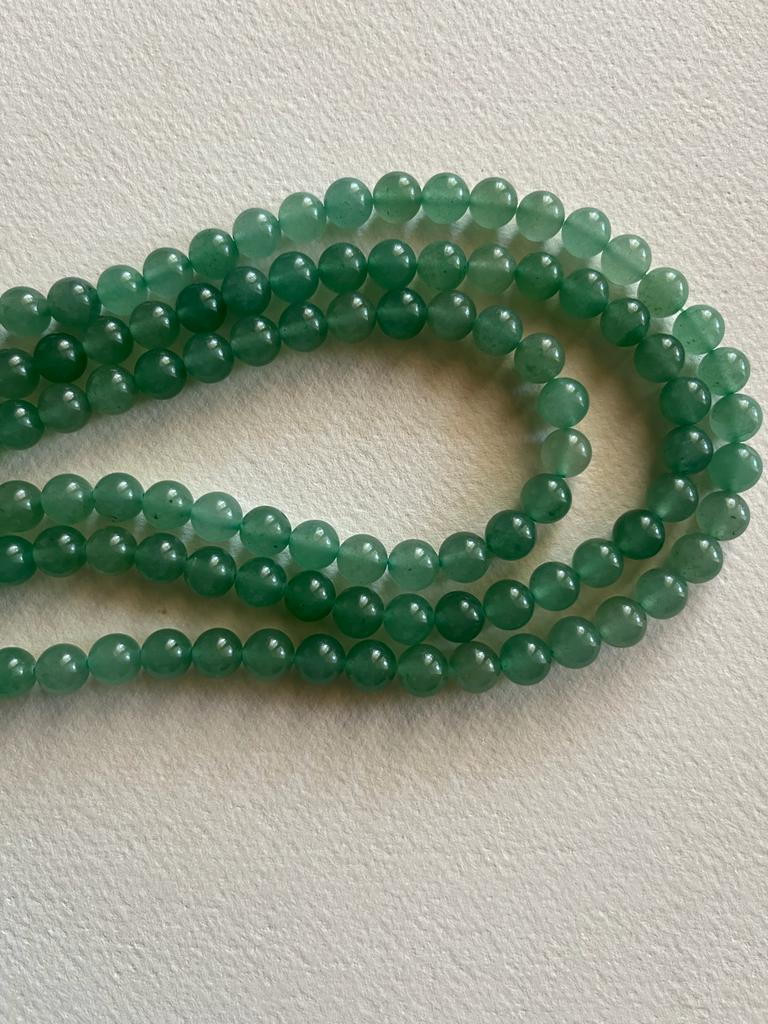 A strand of 8 mm Green Aventurine beads, showcasing their natural green color and smooth finish, perfect for jewelry making.