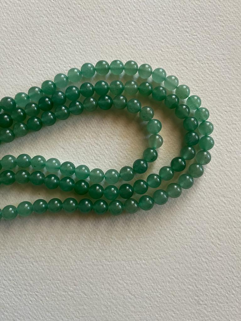 A strand of 8 mm Green Aventurine beads, showcasing their natural green color and smooth finish, perfect for jewelry making.