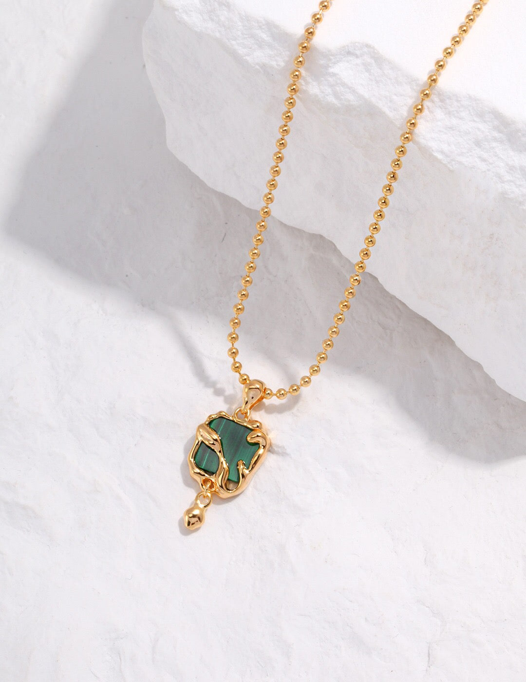 A handcrafted Green Malachite Pendant Necklace featuring a natural malachite stone set in gold vermeil, elegantly displayed on a soft background.