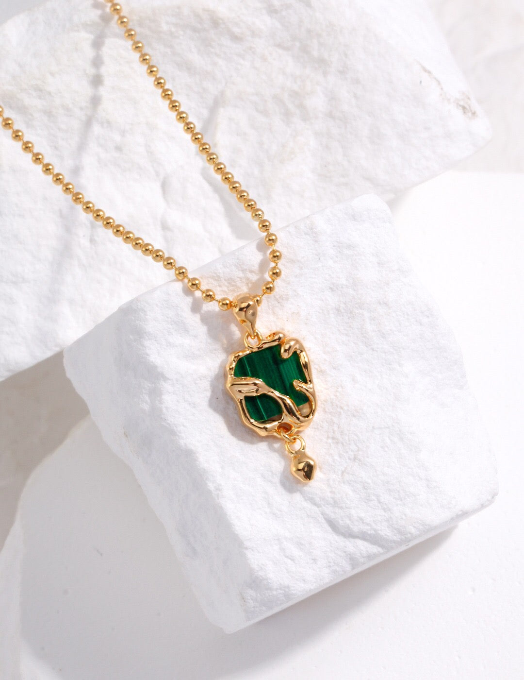 A handcrafted Green Malachite Pendant Necklace featuring a natural malachite stone set in gold vermeil, elegantly displayed on a soft background.