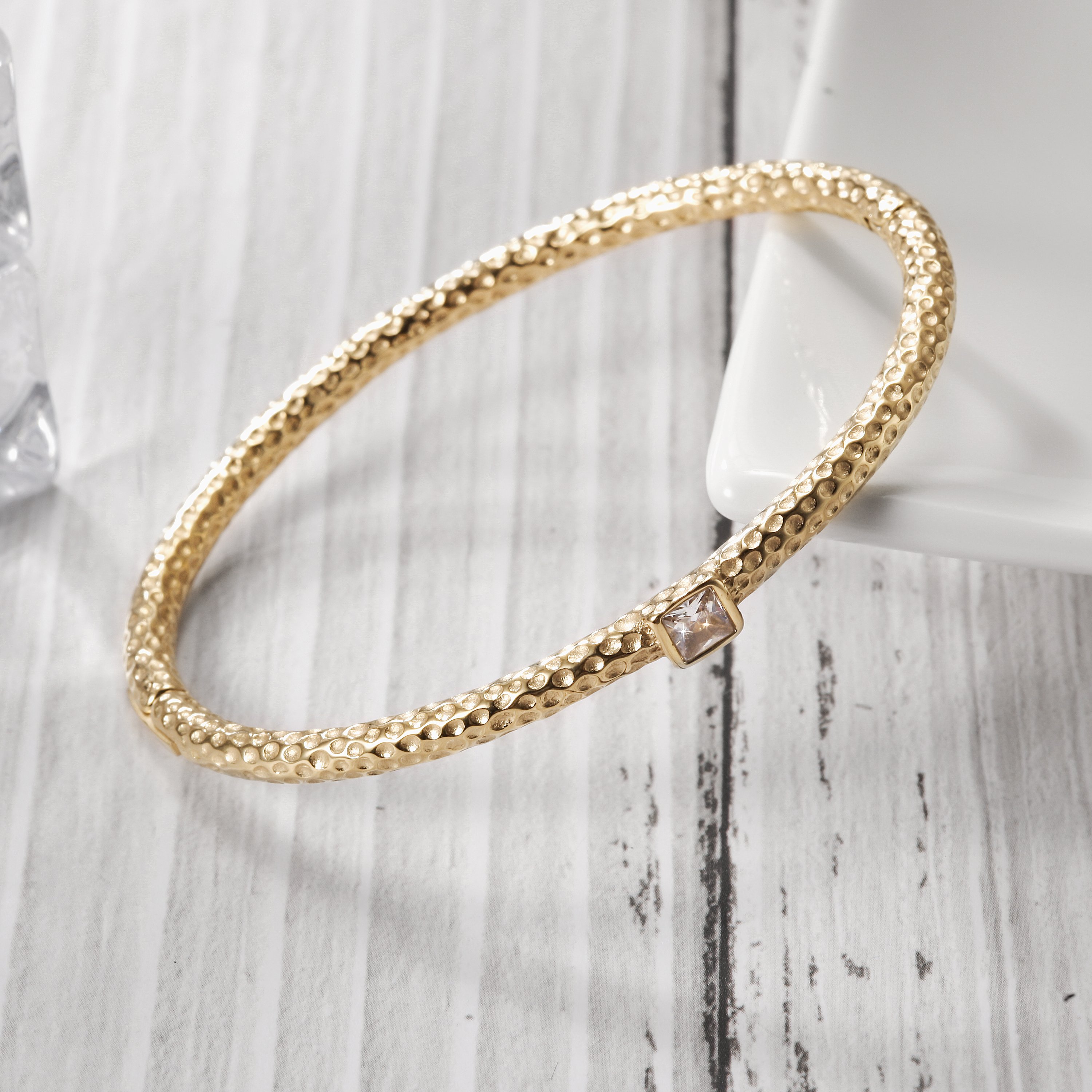 Hammered stacking bangle bracelet made of stainless steel with gold plating, showcasing a unique hammered texture.