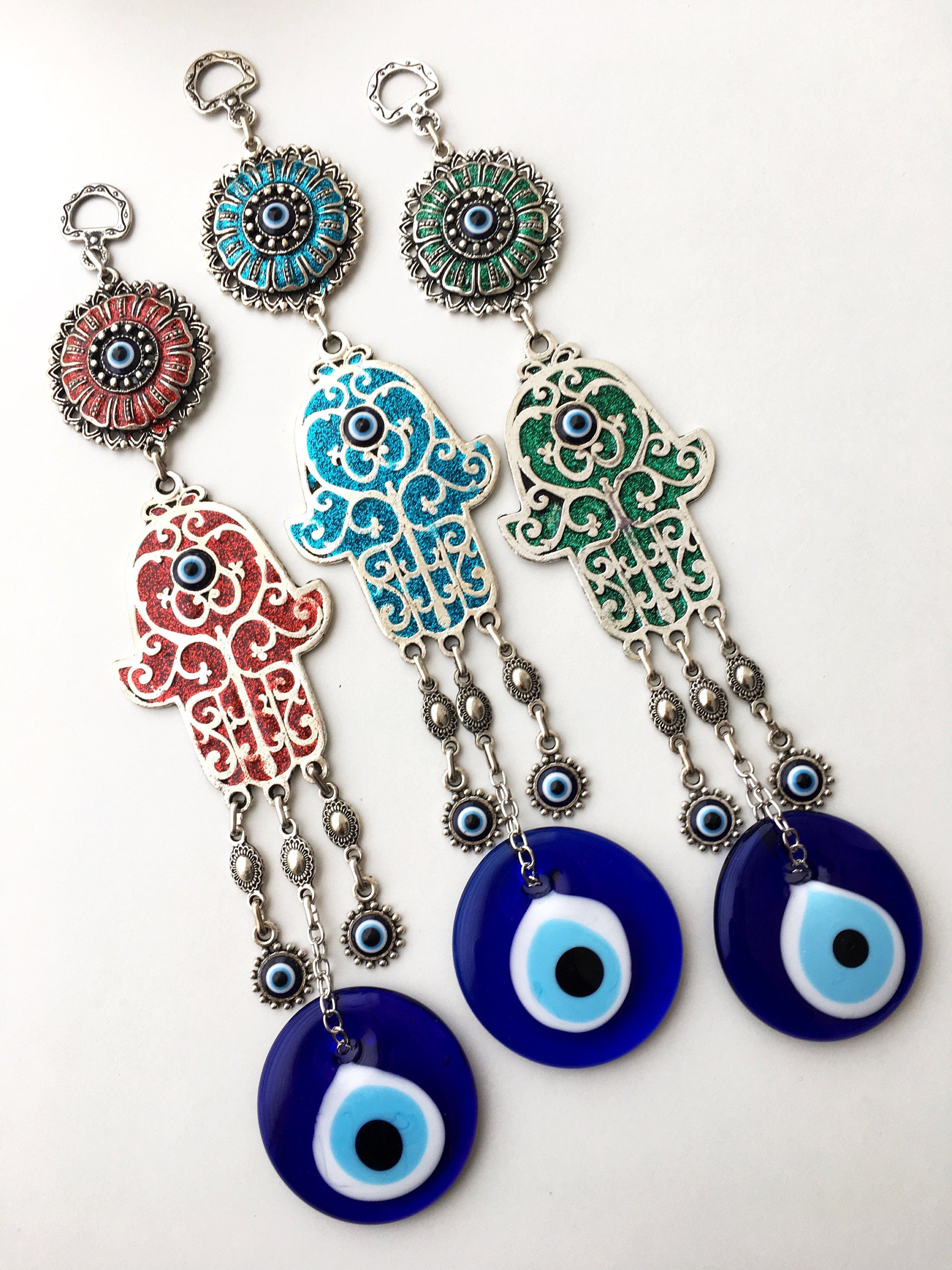 Hamsa Evil Eye Wall Art featuring a mosaic metal hand and a large evil eye bead in vibrant colors.