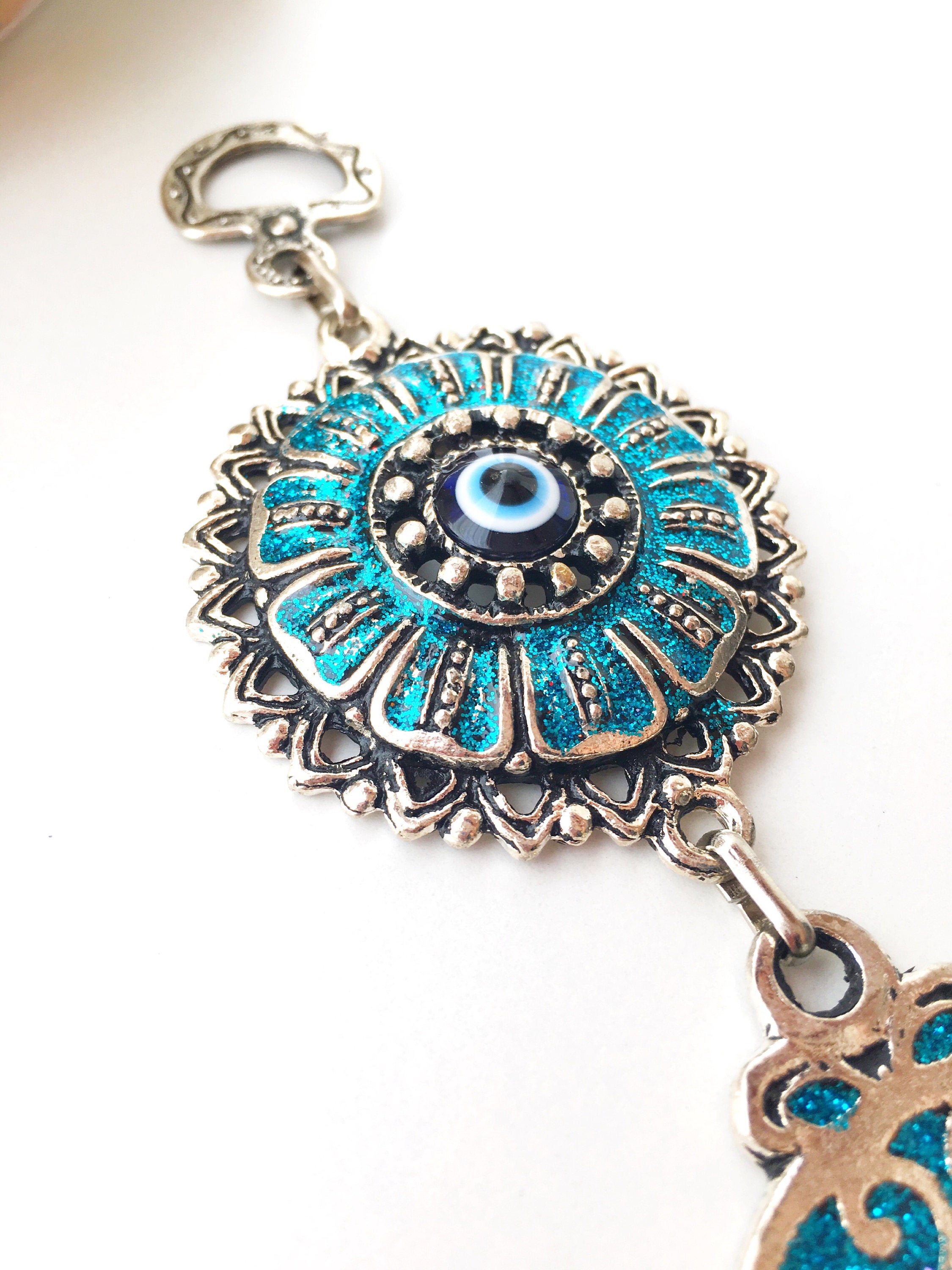 Hamsa Evil Eye Wall Art featuring a mosaic metal hand and a large evil eye bead in vibrant colors.