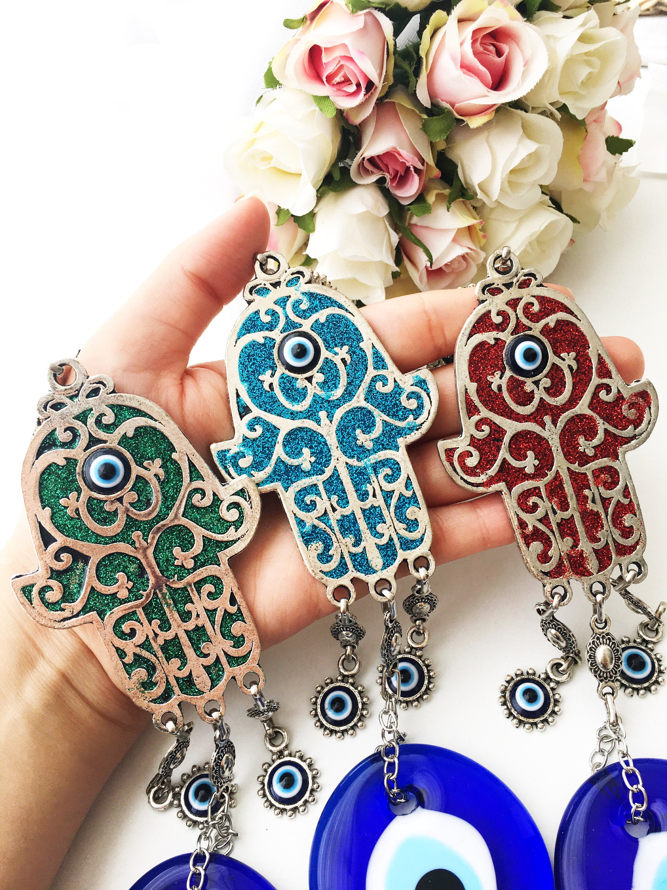 Hamsa Evil Eye Wall Art featuring a mosaic metal hand and a large evil eye bead in vibrant colors.