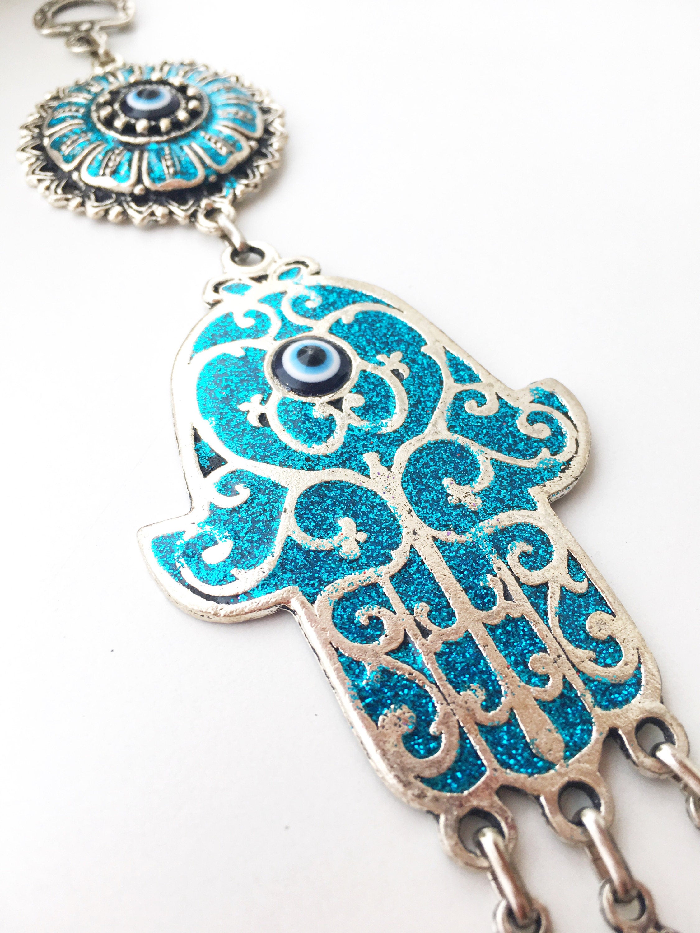 Hamsa Evil Eye Wall Art featuring a mosaic metal hand and a large evil eye bead in vibrant colors.