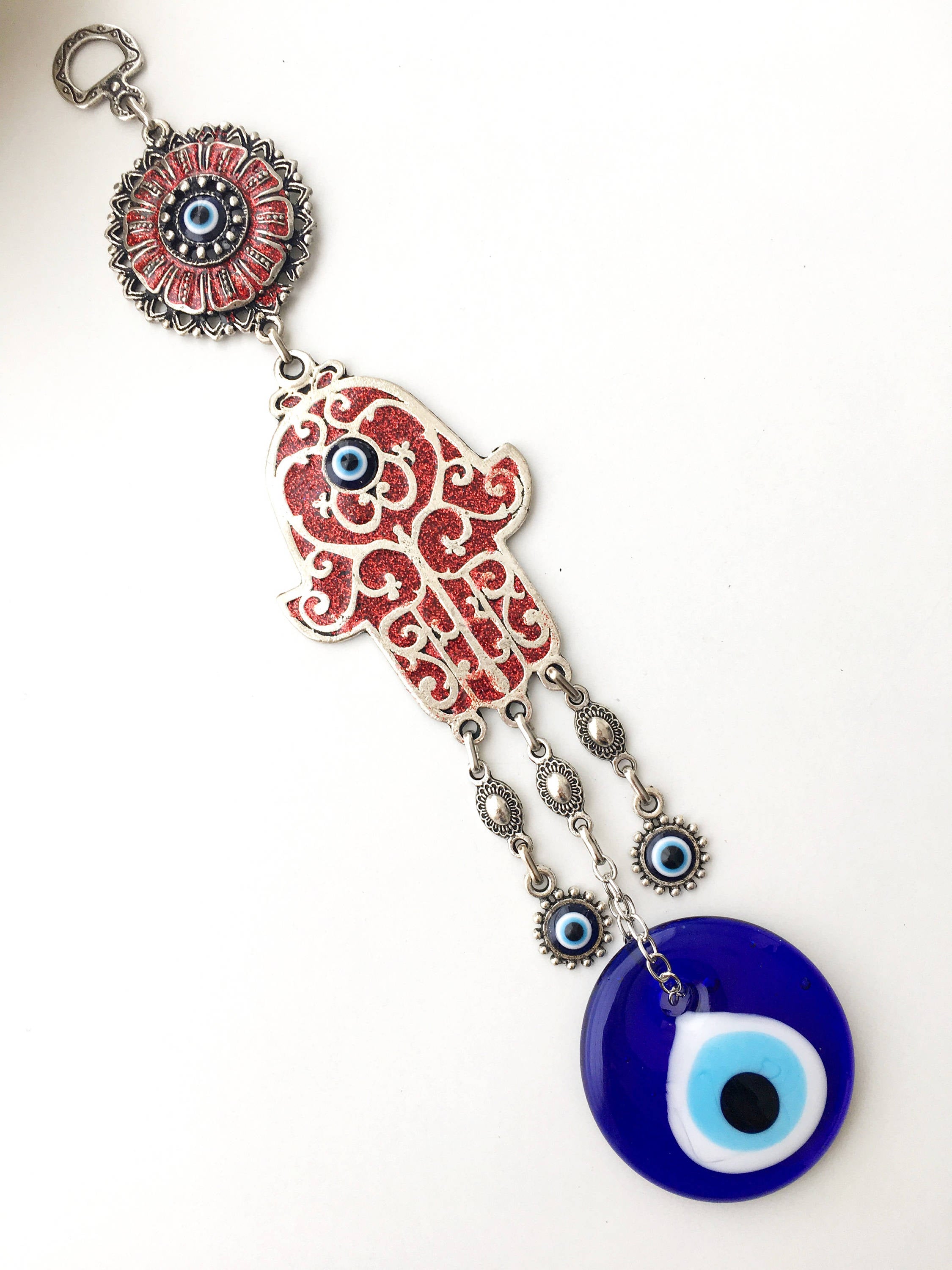 Hamsa Evil Eye Wall Art featuring a mosaic metal hand and a large evil eye bead in vibrant colors.