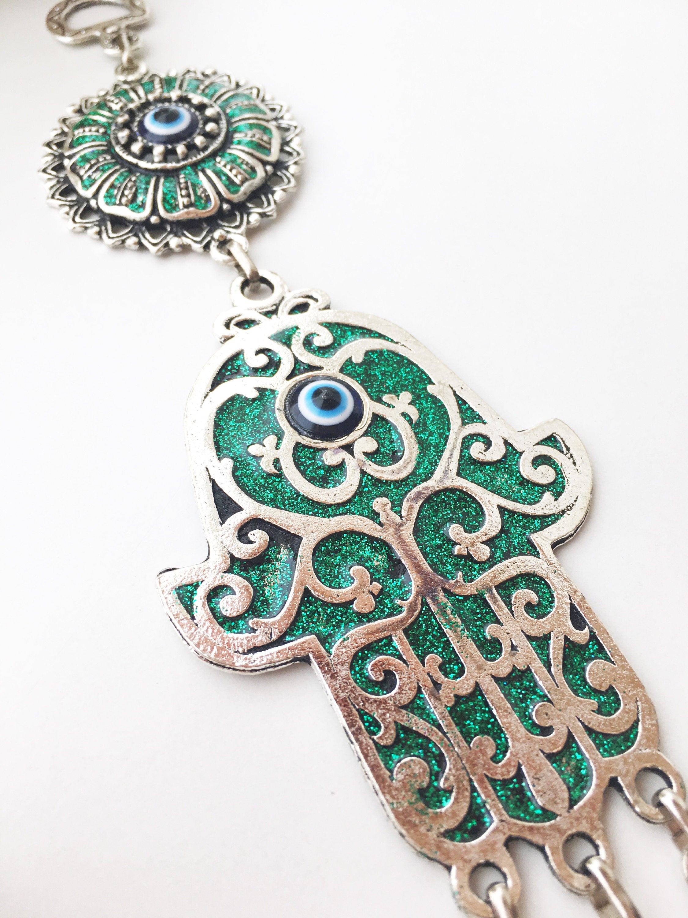 Hamsa Evil Eye Wall Art featuring a mosaic metal hand and a large evil eye bead in vibrant colors.