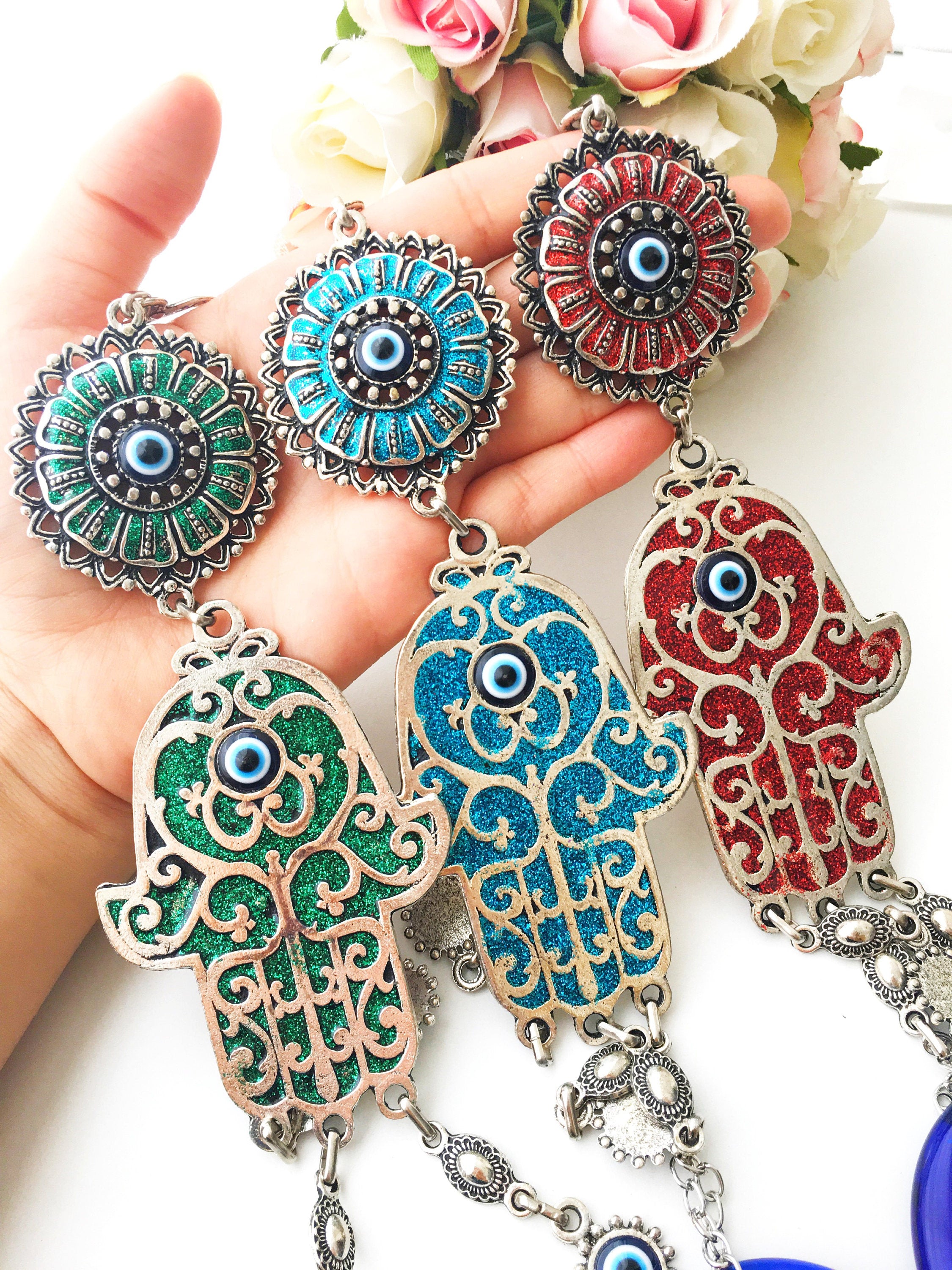 Hamsa Evil Eye Wall Art featuring a mosaic metal hand and a large evil eye bead in vibrant colors.