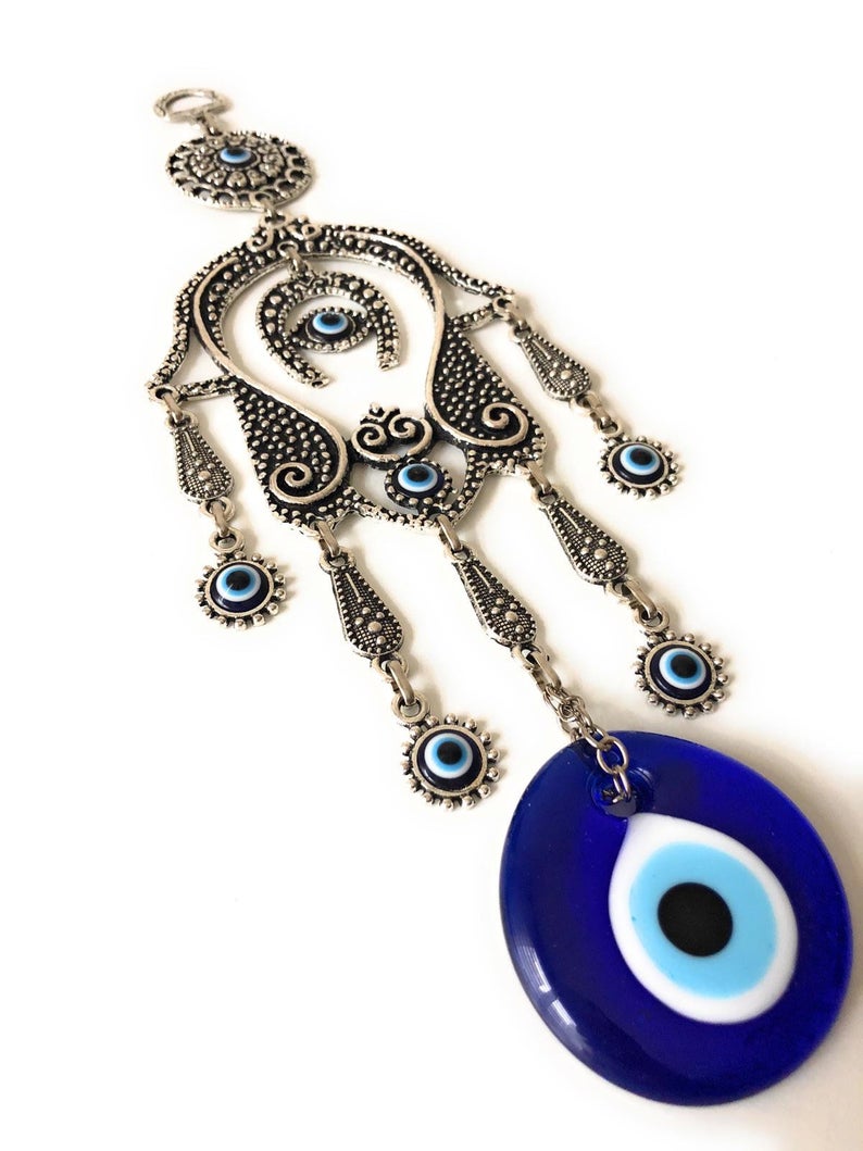 A beautifully crafted Hamsa evil eye wall decor featuring a mosaic metal hand and a large evil eye bead, symbolizing protection and good luck.