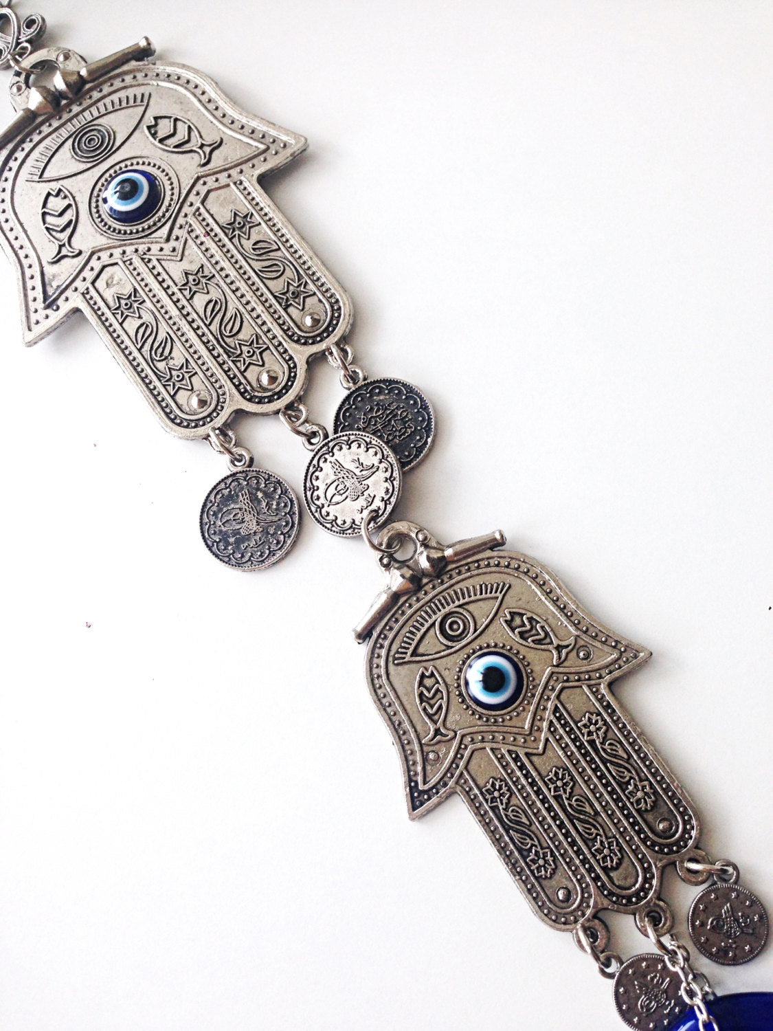 A beautifully crafted Hamsa Evil Eye Wall Hanging featuring a metal Hamsa hand and a large evil eye bead, symbolizing protection and good luck.