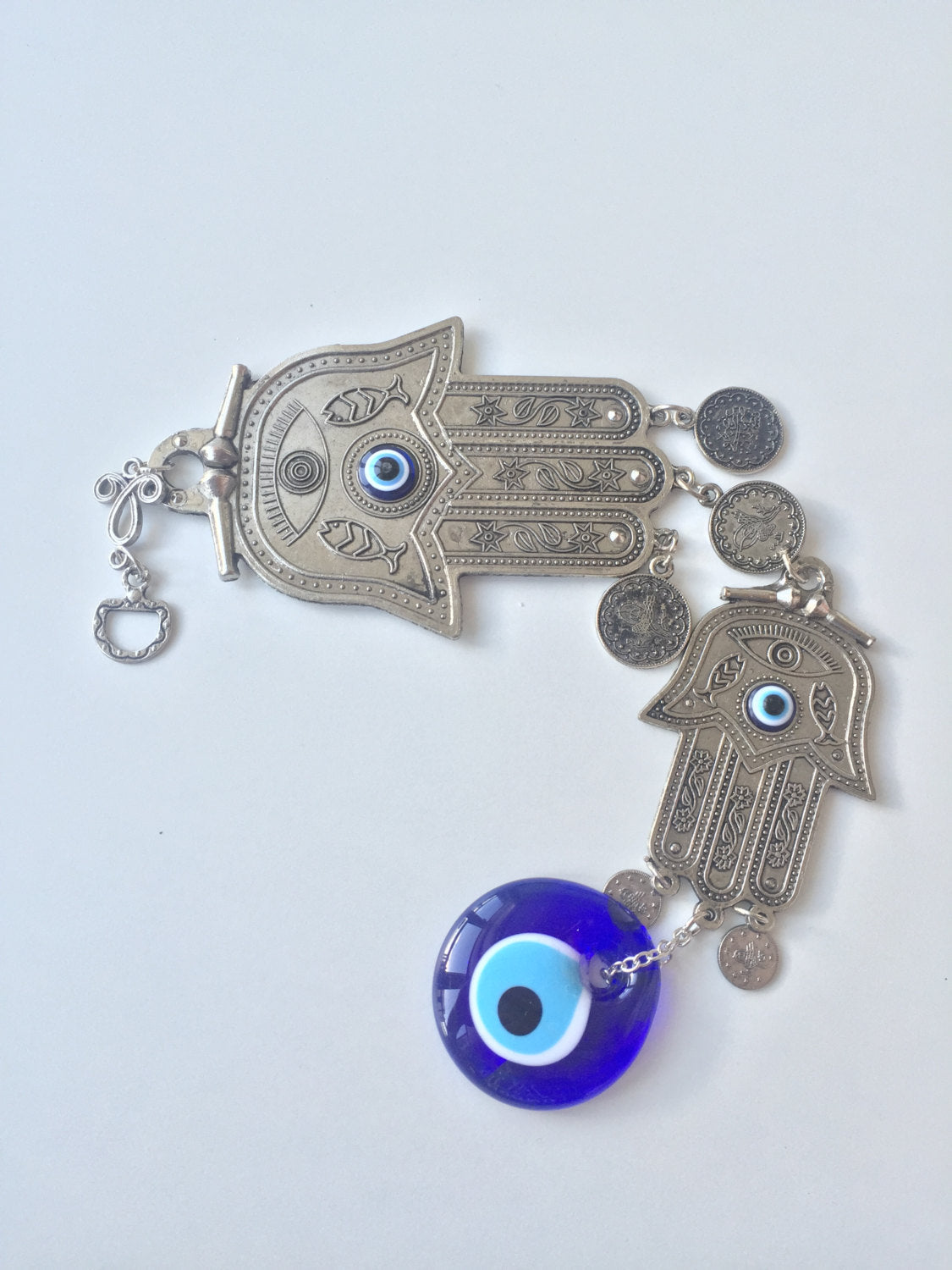 A beautifully crafted Hamsa Evil Eye Wall Hanging featuring a metal Hamsa hand and a large evil eye bead, symbolizing protection and good luck.