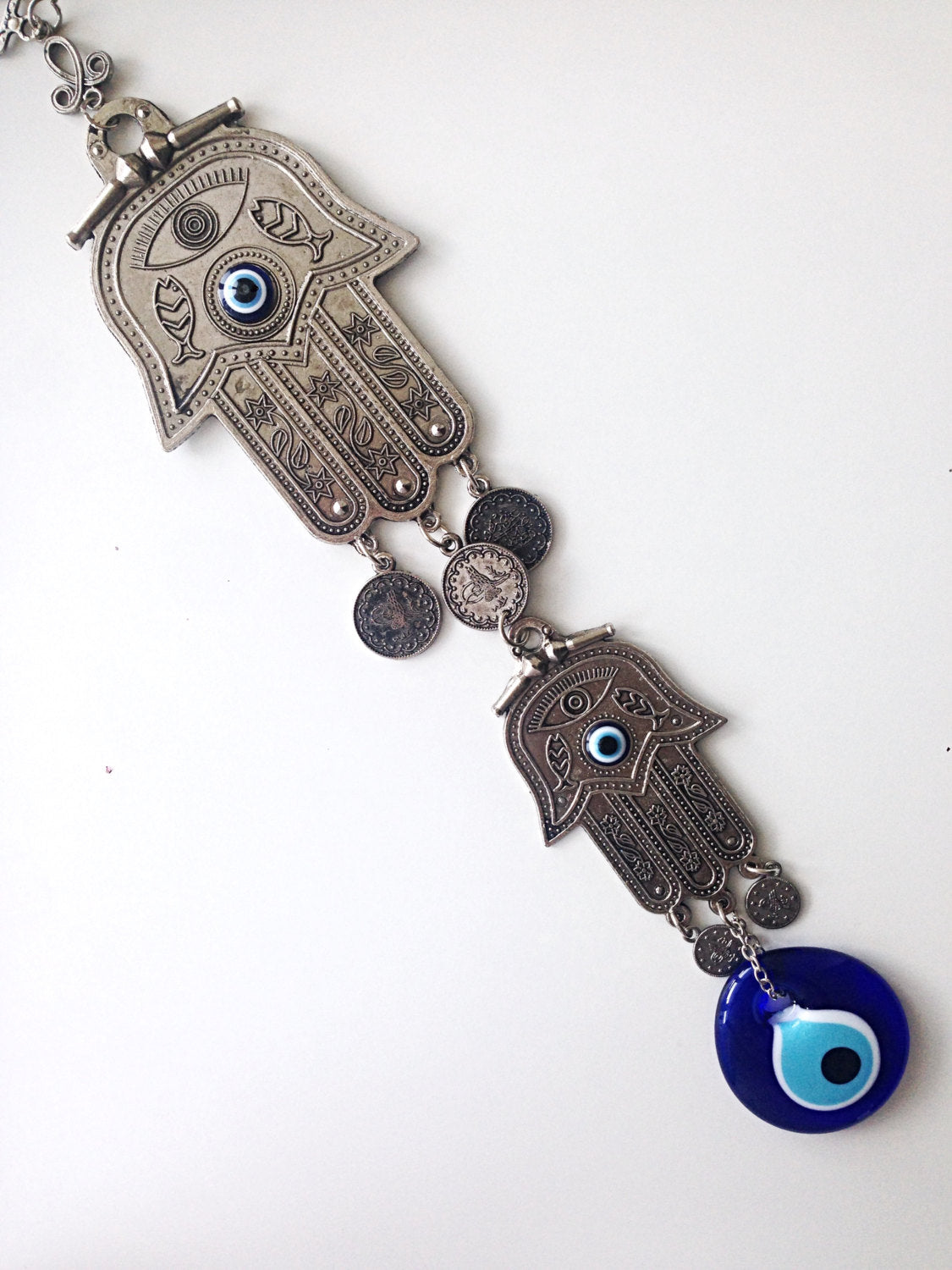 A beautifully crafted Hamsa Evil Eye Wall Hanging featuring a metal Hamsa hand and a large evil eye bead, symbolizing protection and good luck.