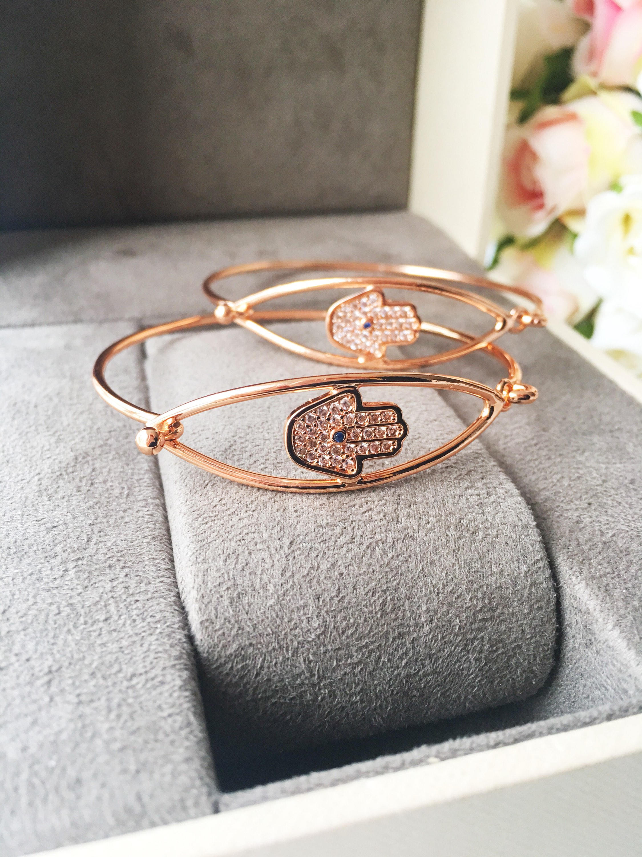 A beautiful rose gold Hamsa Hand Bracelet featuring a movable charm and adjustable design, showcasing its elegant craftsmanship.