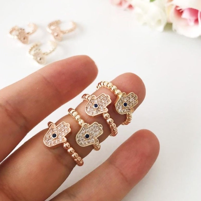 A beautiful adjustable Hamsa Hand Ring in rose gold featuring cubic zirconia beads, symbolizing protection and good fortune.