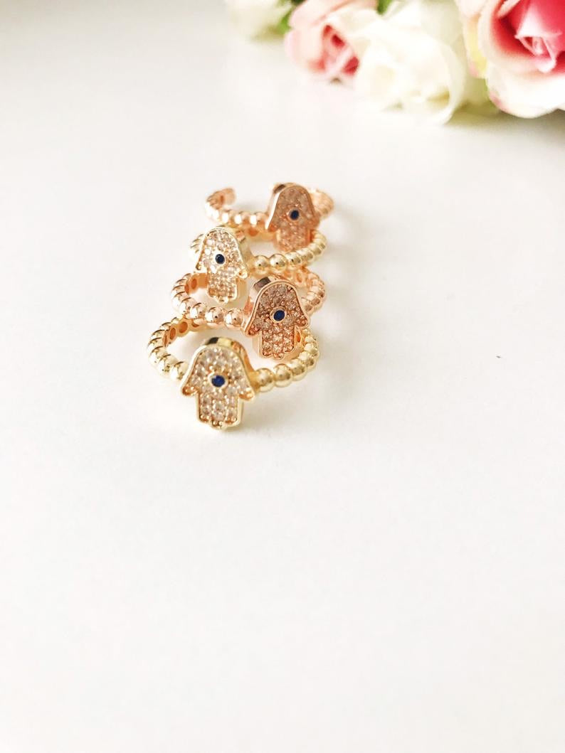 A beautiful adjustable Hamsa Hand Ring in rose gold featuring cubic zirconia beads, symbolizing protection and good fortune.