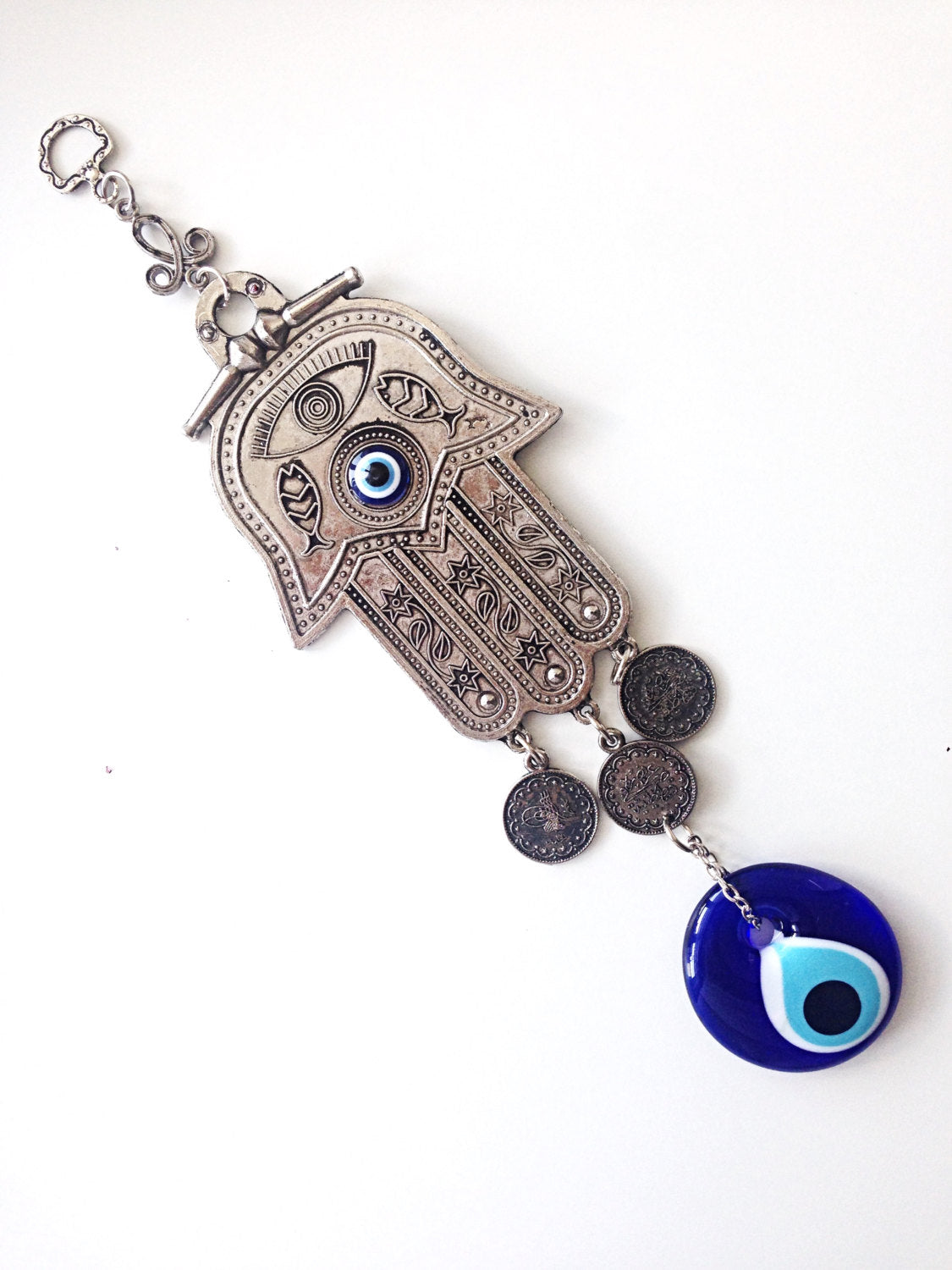 Hamsa wall art featuring a metal hand and large evil eye bead, symbolizing protection and good luck, beautifully crafted for home decor.