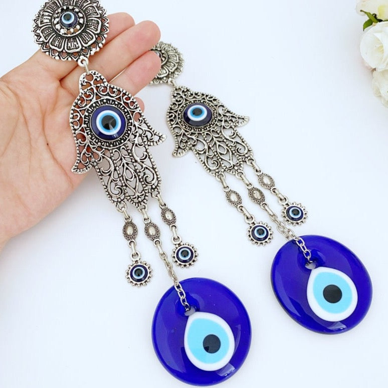 A beautifully crafted Hamsa wall decor featuring an evil eye design, made of metal with vibrant glass accents, perfect for home protection.