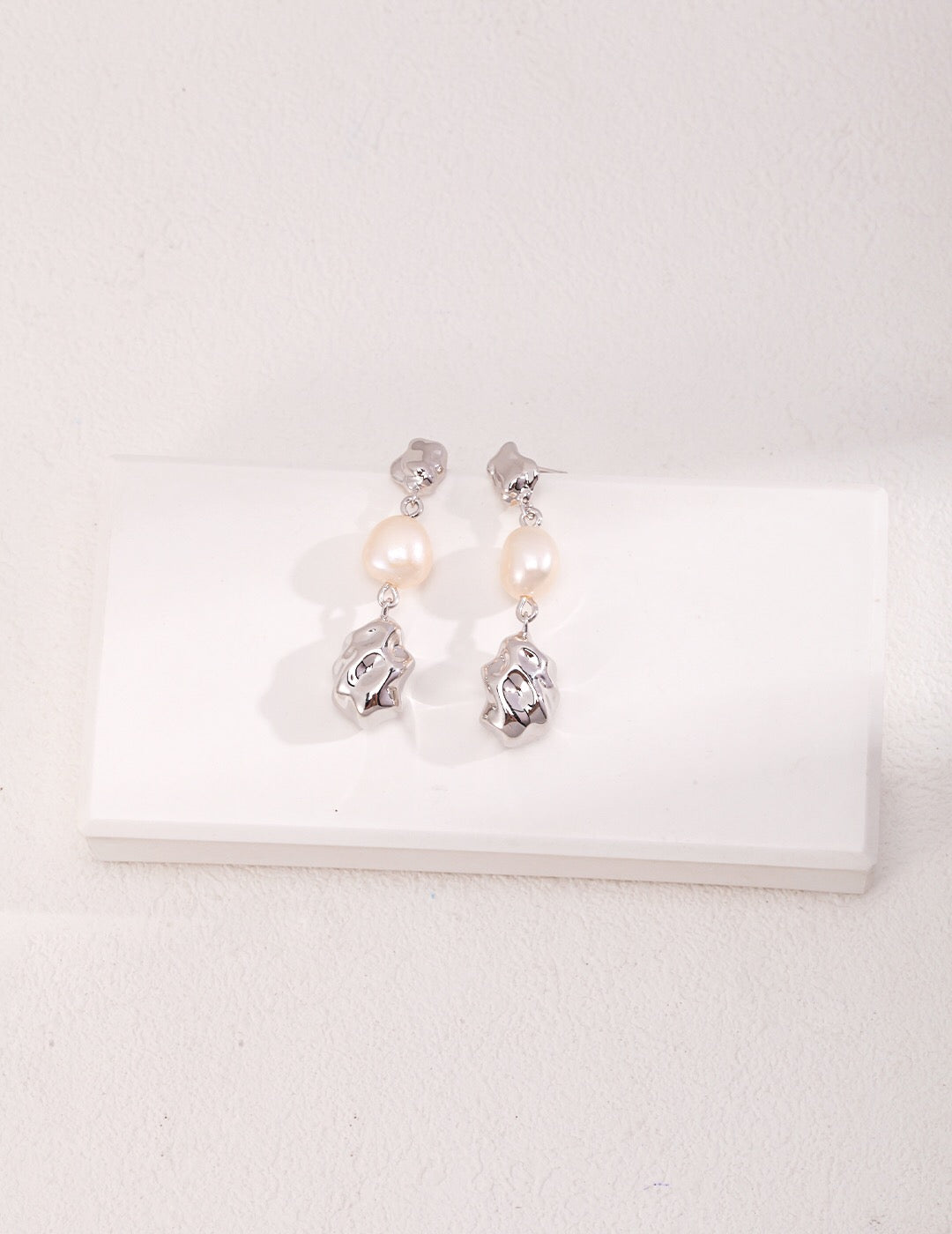 Elegant hand carved style pearl earrings featuring natural freshwater pearls and sterling silver with gold vermeil accents.