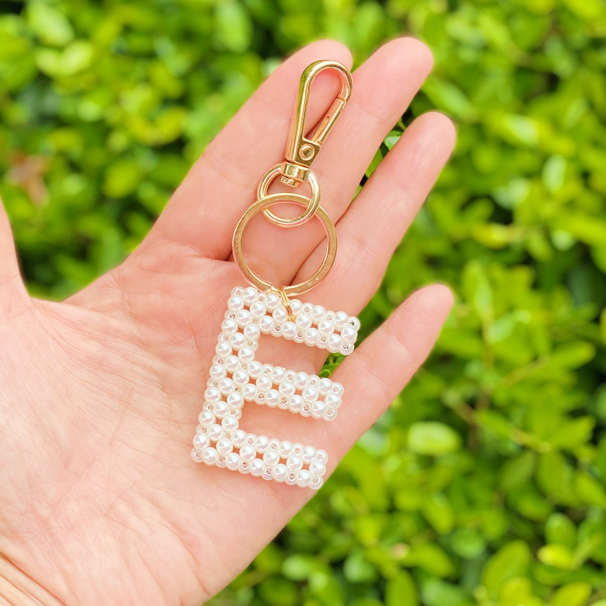 Hand knitted retro pearl initial key chain featuring pearl beads and gold tone hardware, personalized with an initial charm.