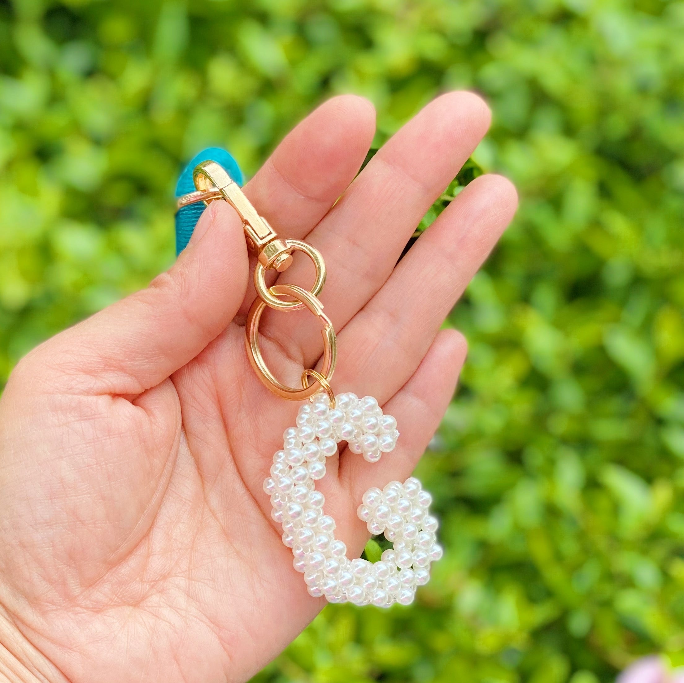 Hand knitted retro pearl initial key chain featuring pearl beads and gold tone hardware, personalized with an initial charm.