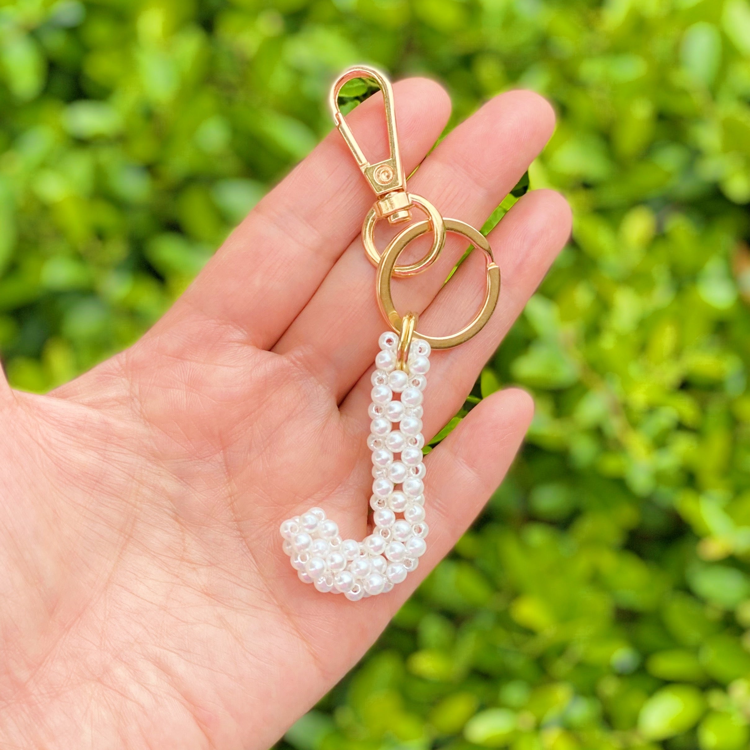 Hand knitted retro pearl initial key chain featuring pearl beads and gold tone hardware, personalized with an initial charm.