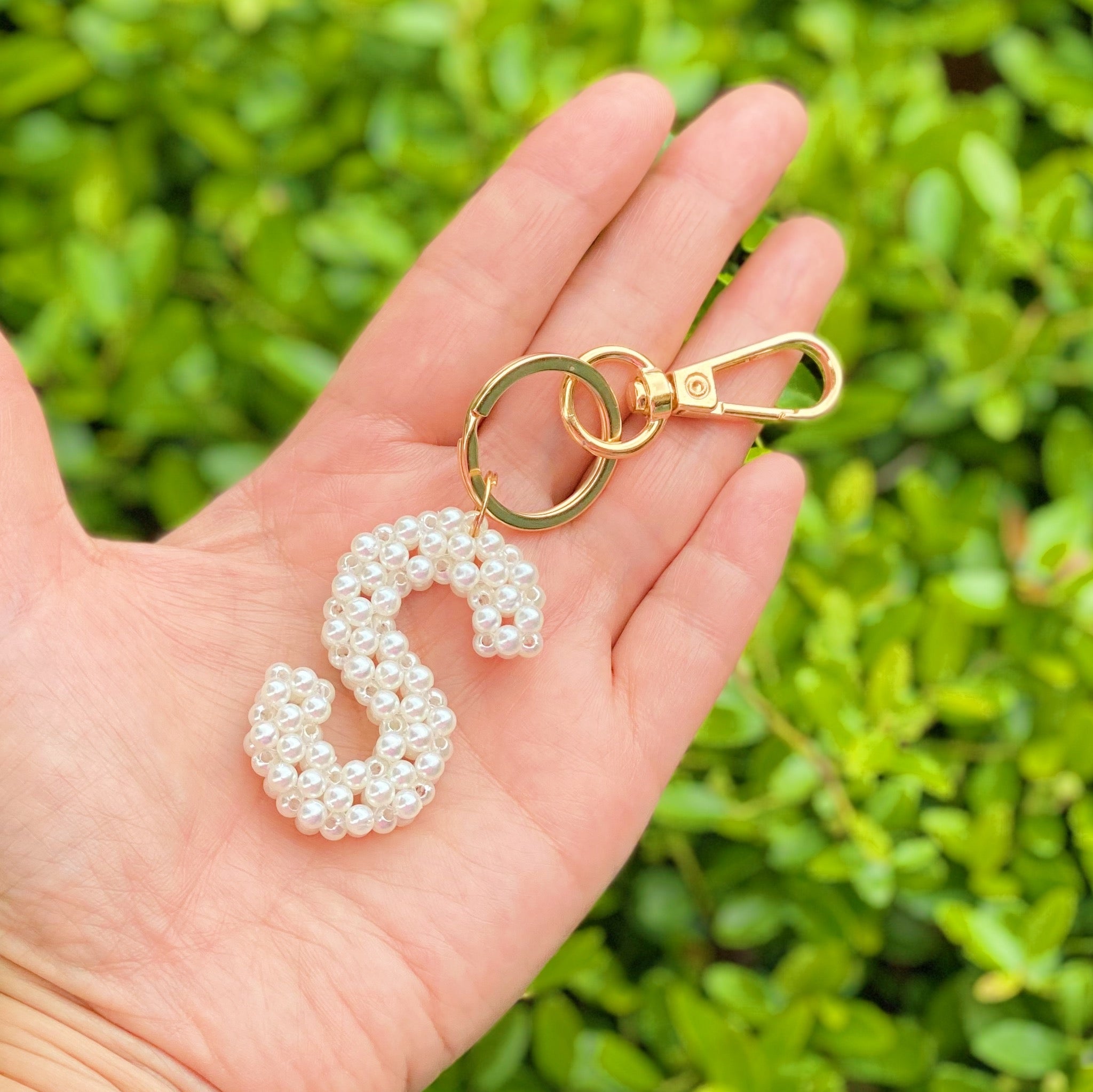 Hand knitted retro pearl initial key chain featuring pearl beads and gold tone hardware, personalized with an initial charm.