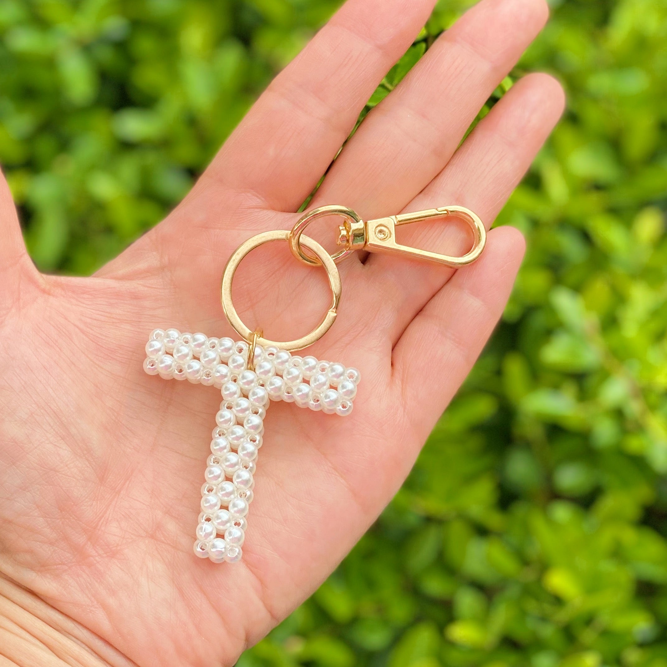 Hand knitted retro pearl initial key chain featuring pearl beads and gold tone hardware, personalized with an initial charm.