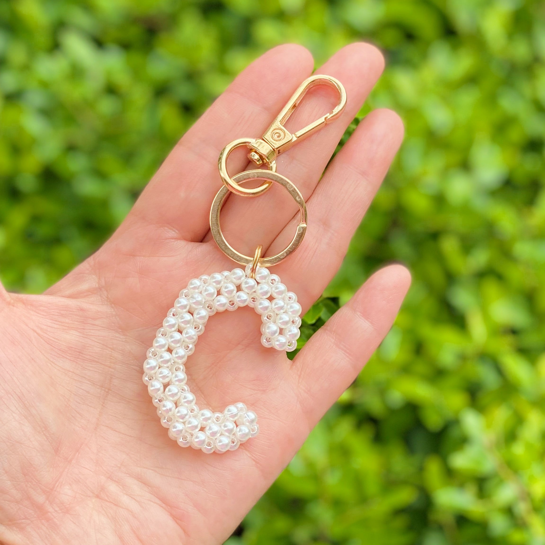 Hand knitted retro pearl initial key chain featuring pearl beads and gold tone hardware, personalized with an initial charm.