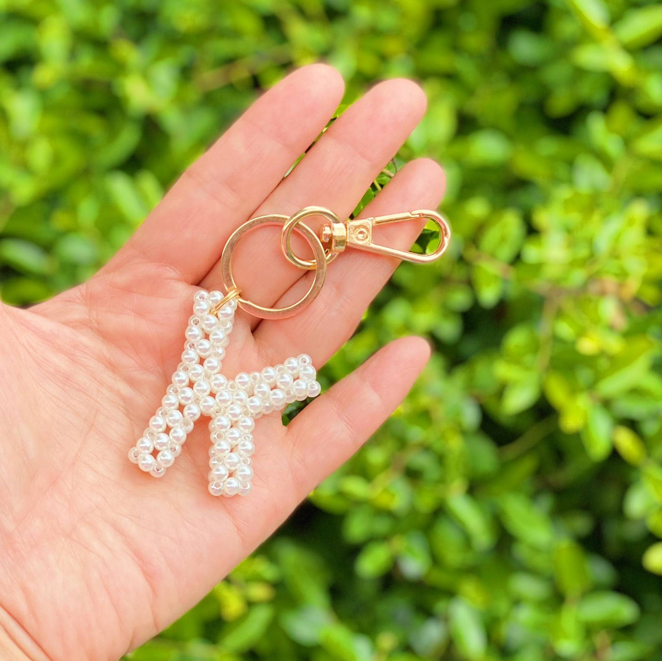 Hand knitted retro pearl initial key chain featuring pearl beads and gold tone hardware, personalized with an initial charm.