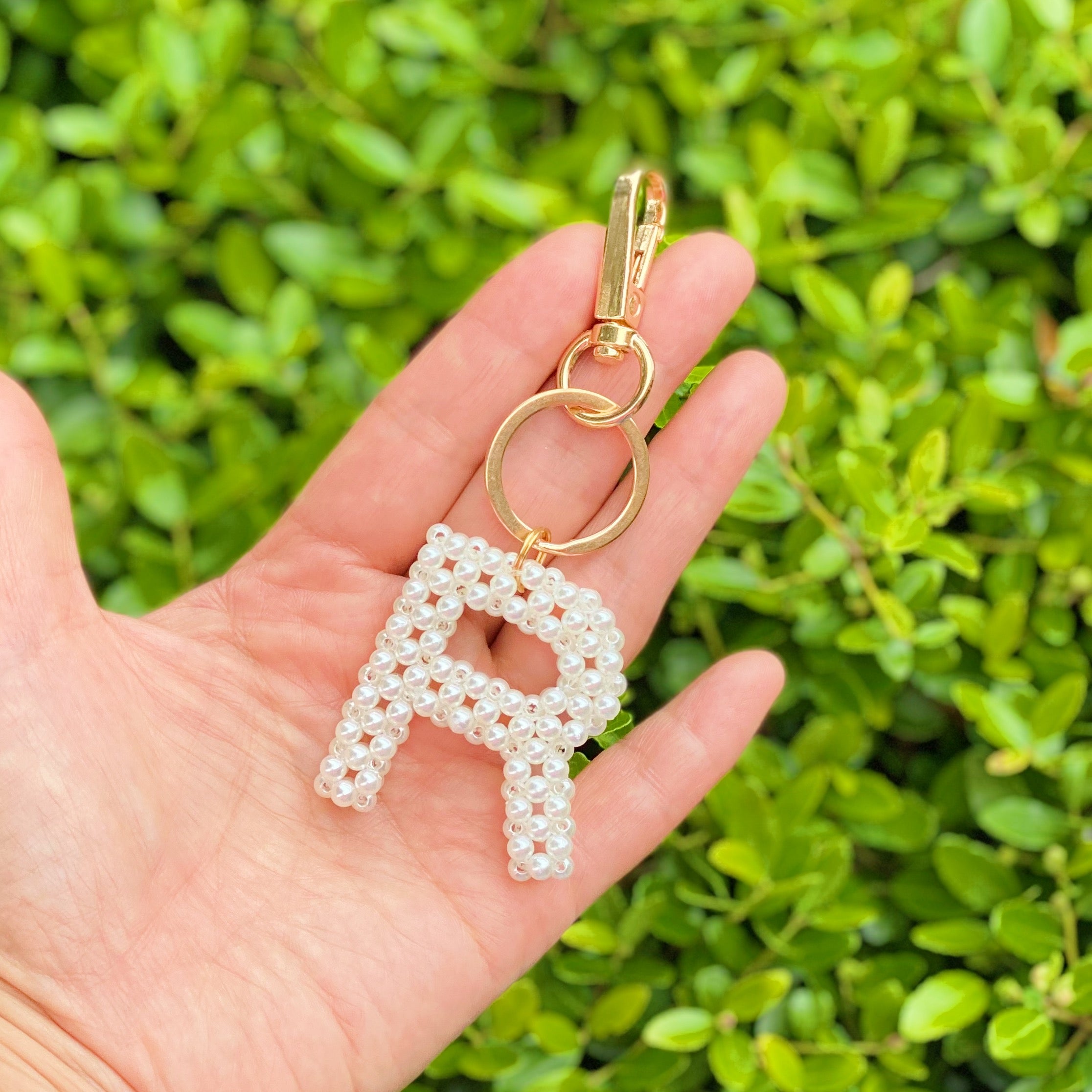 Hand knitted retro pearl initial key chain featuring pearl beads and gold tone hardware, personalized with an initial charm.