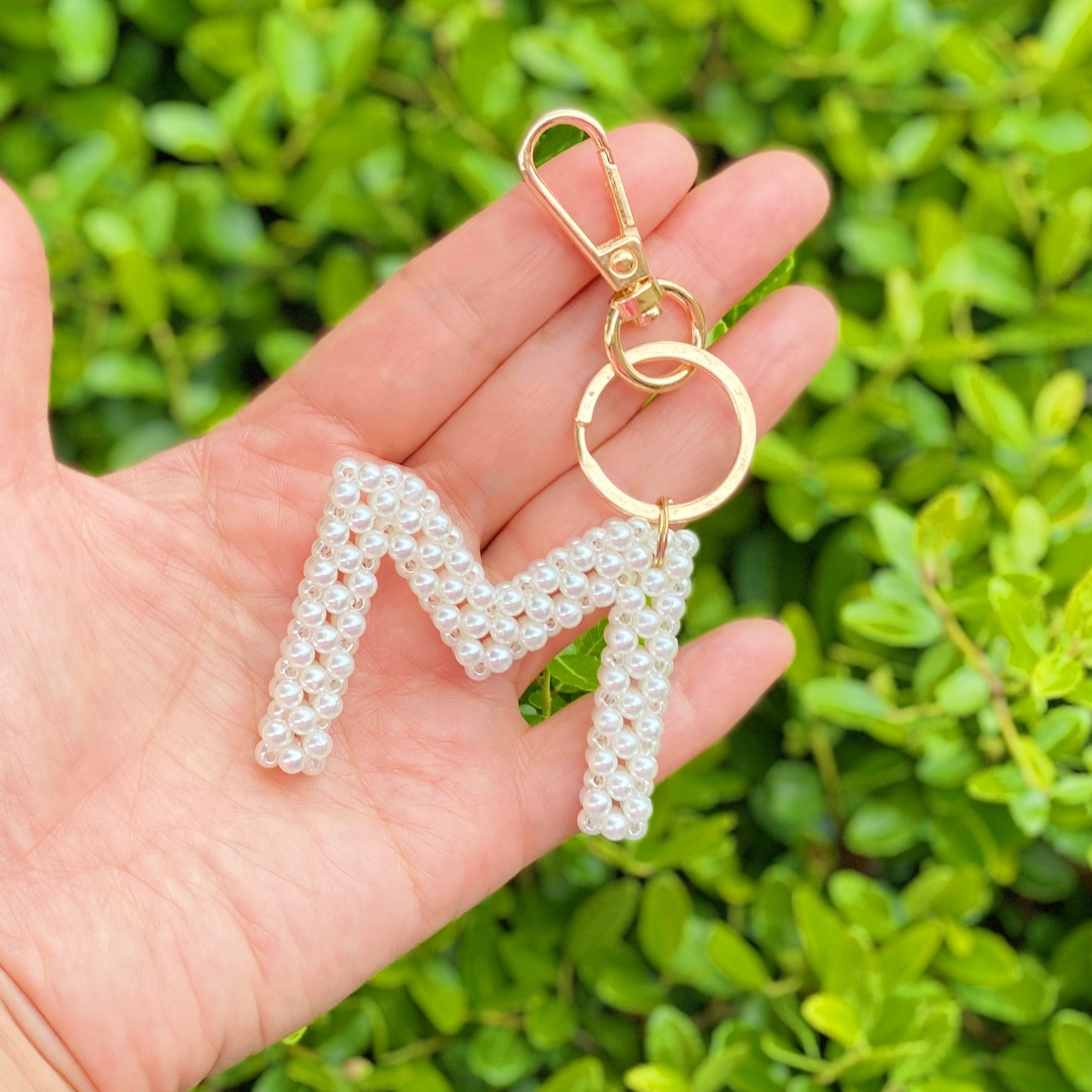 Hand knitted retro pearl initial key chain featuring pearl beads and gold tone hardware, personalized with an initial charm.