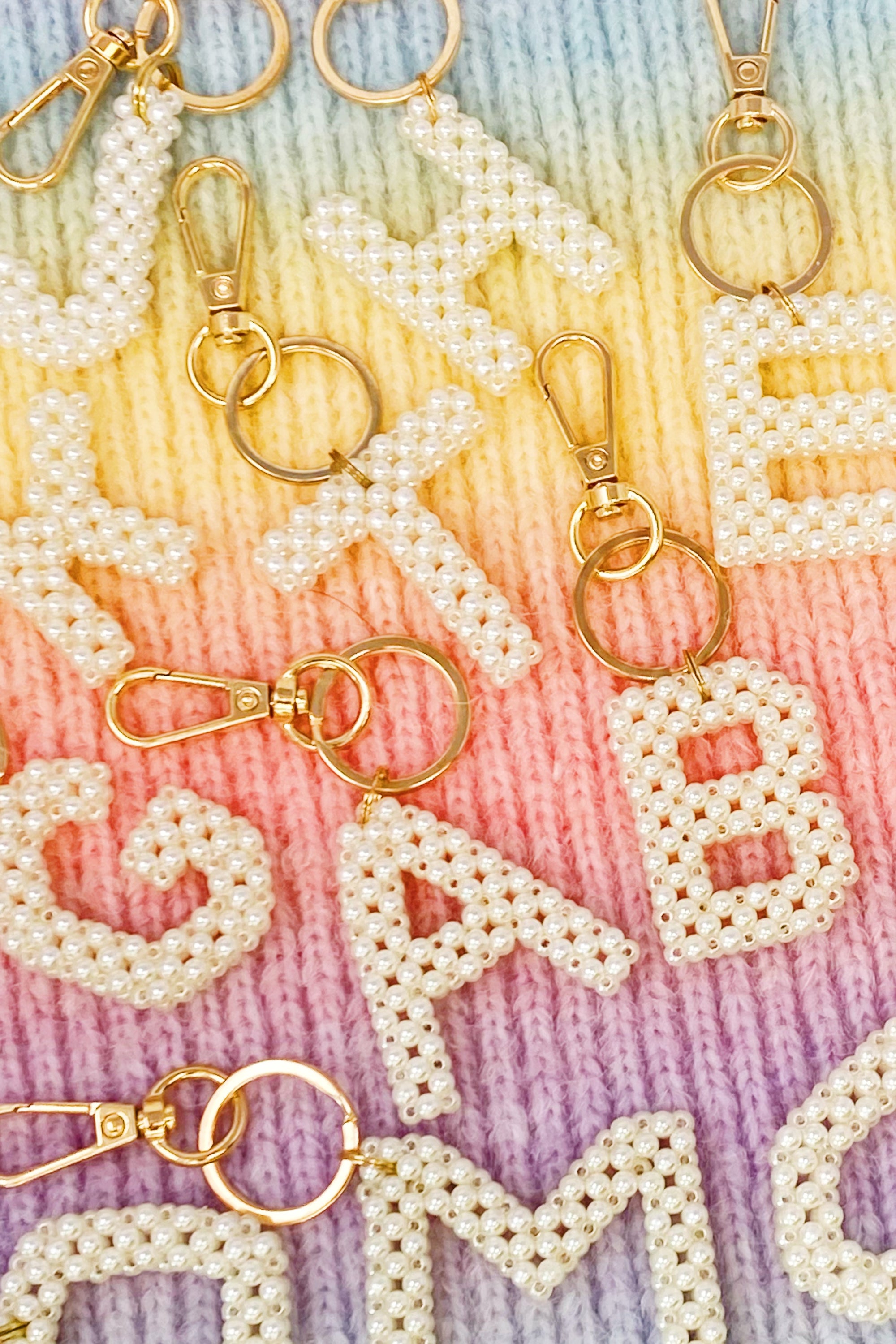 Hand knitted retro pearl initial key chain featuring pearl beads and gold tone hardware, personalized with an initial charm.