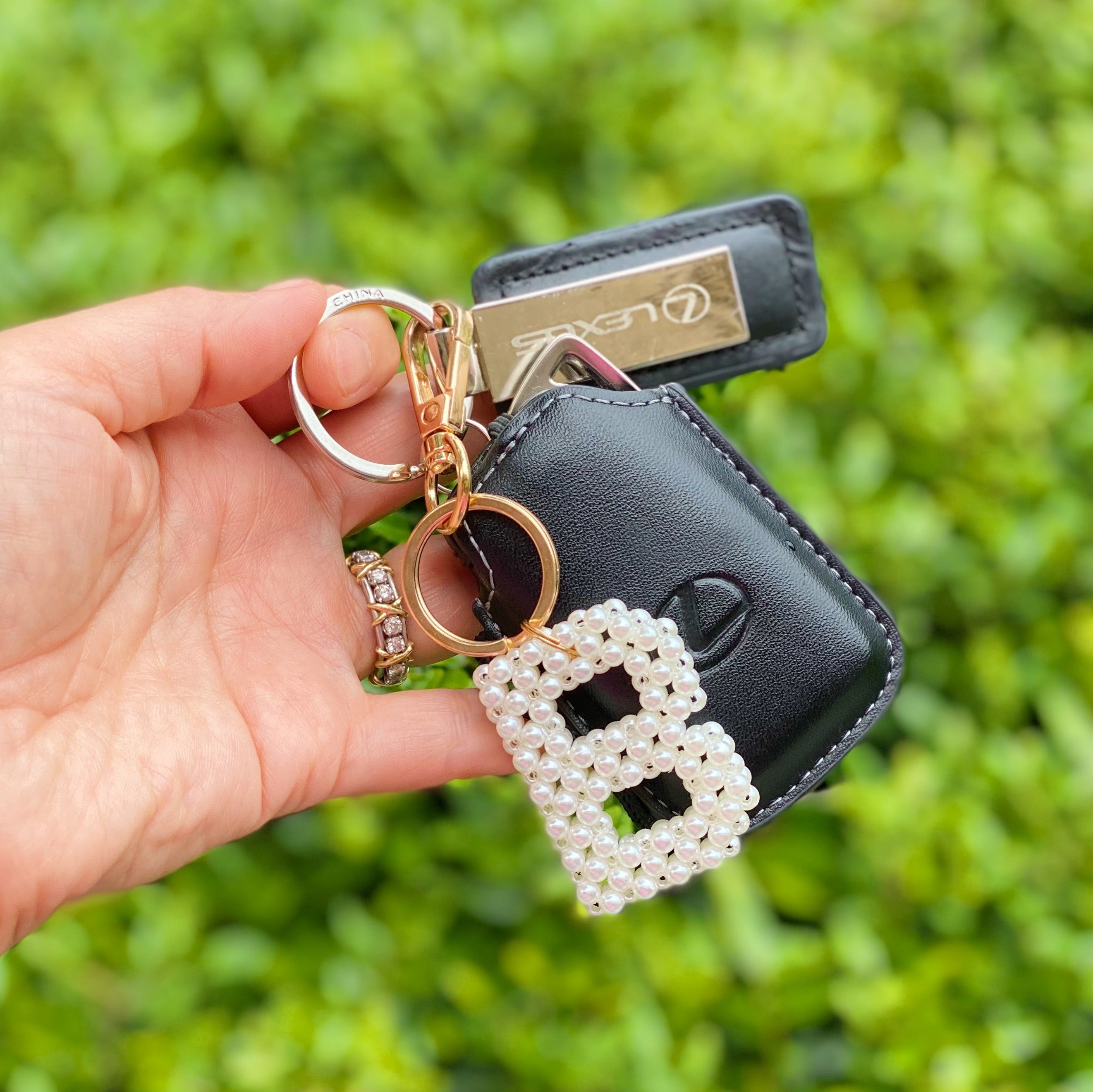 Hand knitted retro pearl initial key chain featuring pearl beads and gold tone hardware, personalized with an initial charm.