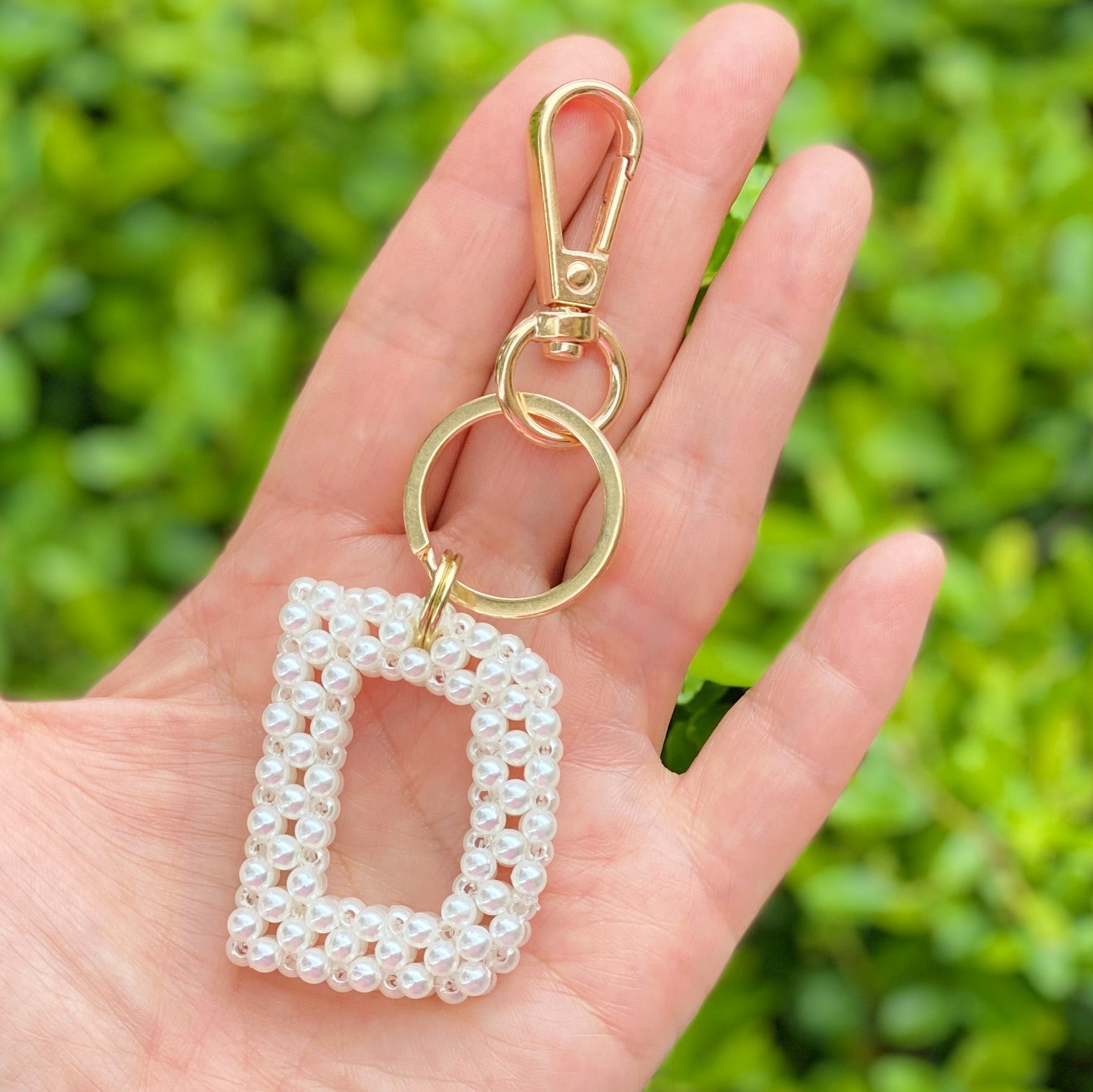 Hand knitted retro pearl initial key chain featuring pearl beads and gold tone hardware, personalized with an initial charm.