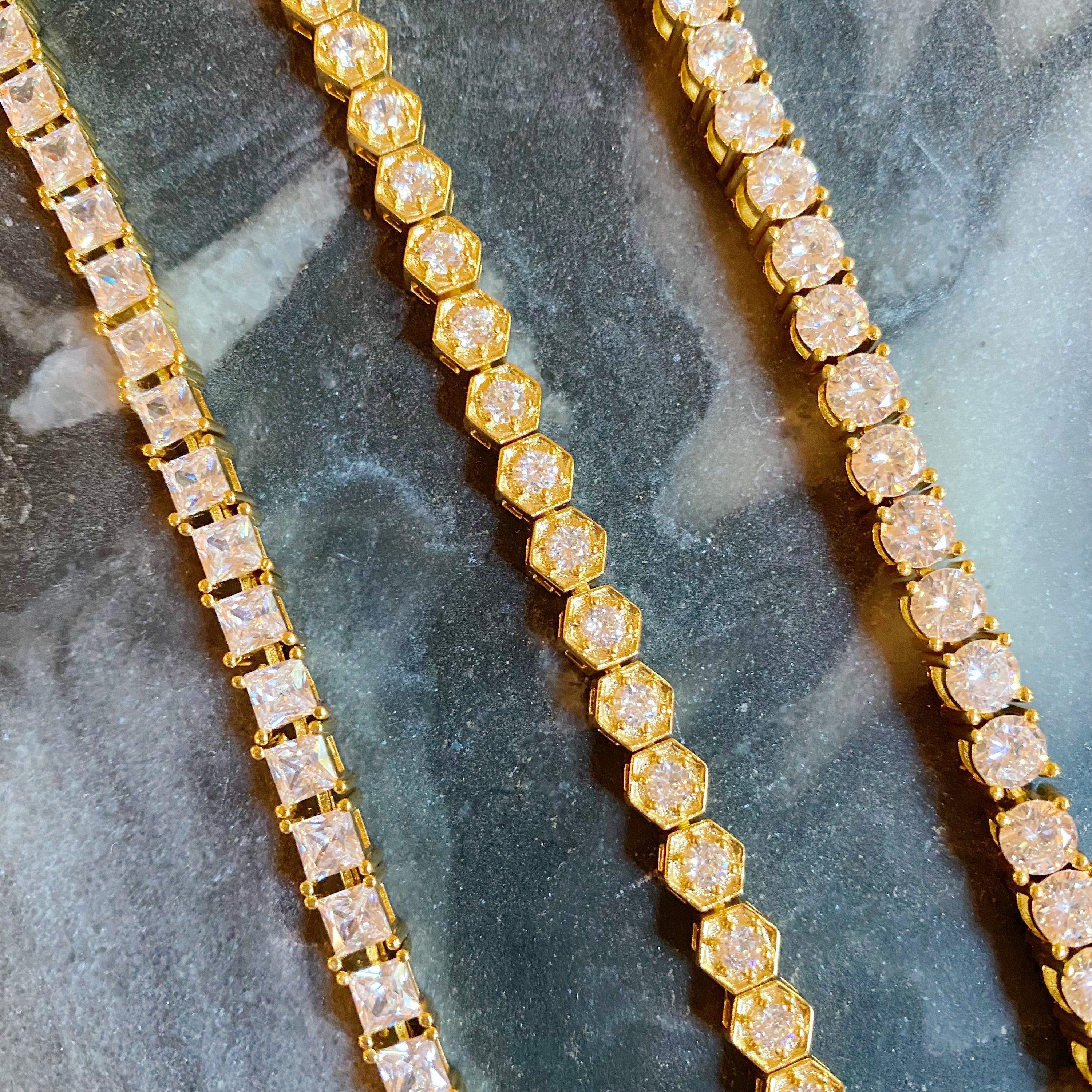 A stunning hand linked high class tennis bracelet featuring AAA grade Cubic Zirconia stones, gold plated brass, and a secure double closure.