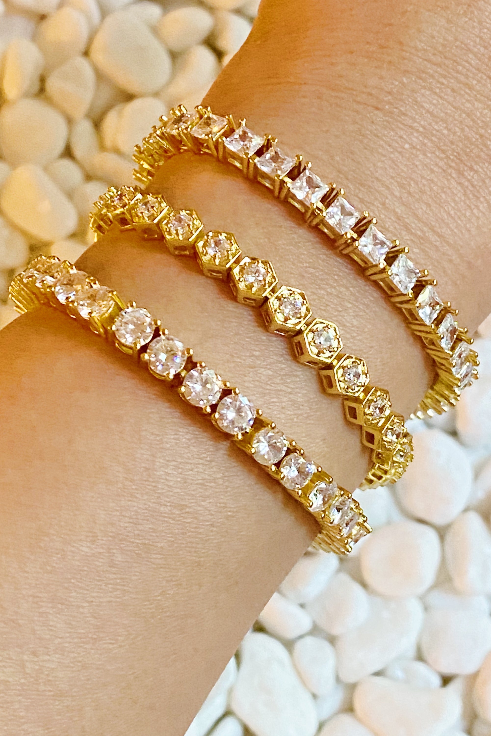 A stunning hand linked high class tennis bracelet featuring AAA grade Cubic Zirconia stones, gold plated brass, and a secure double closure.