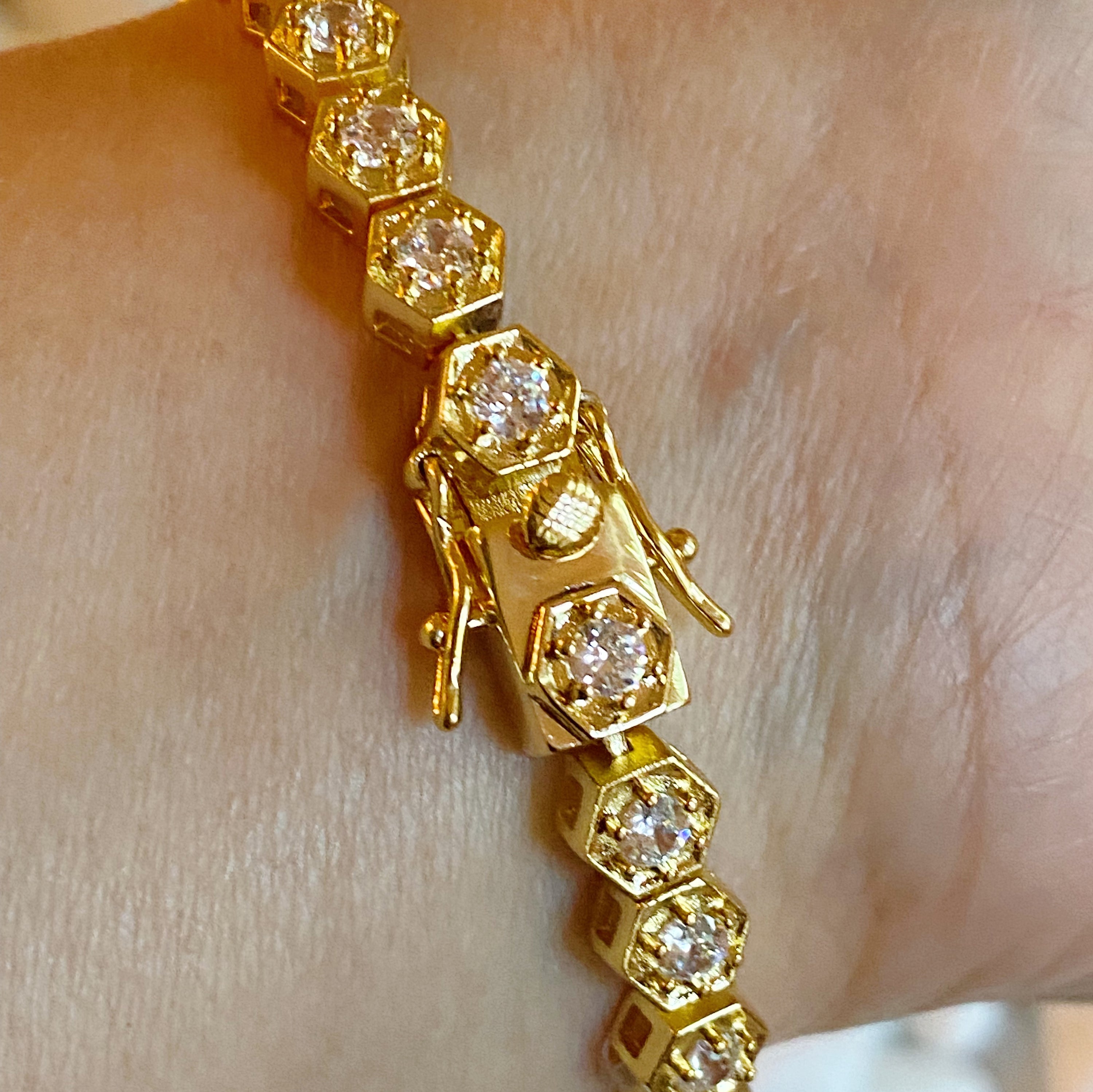 A stunning hand linked high class tennis bracelet featuring AAA grade Cubic Zirconia stones, gold plated brass, and a secure double closure.