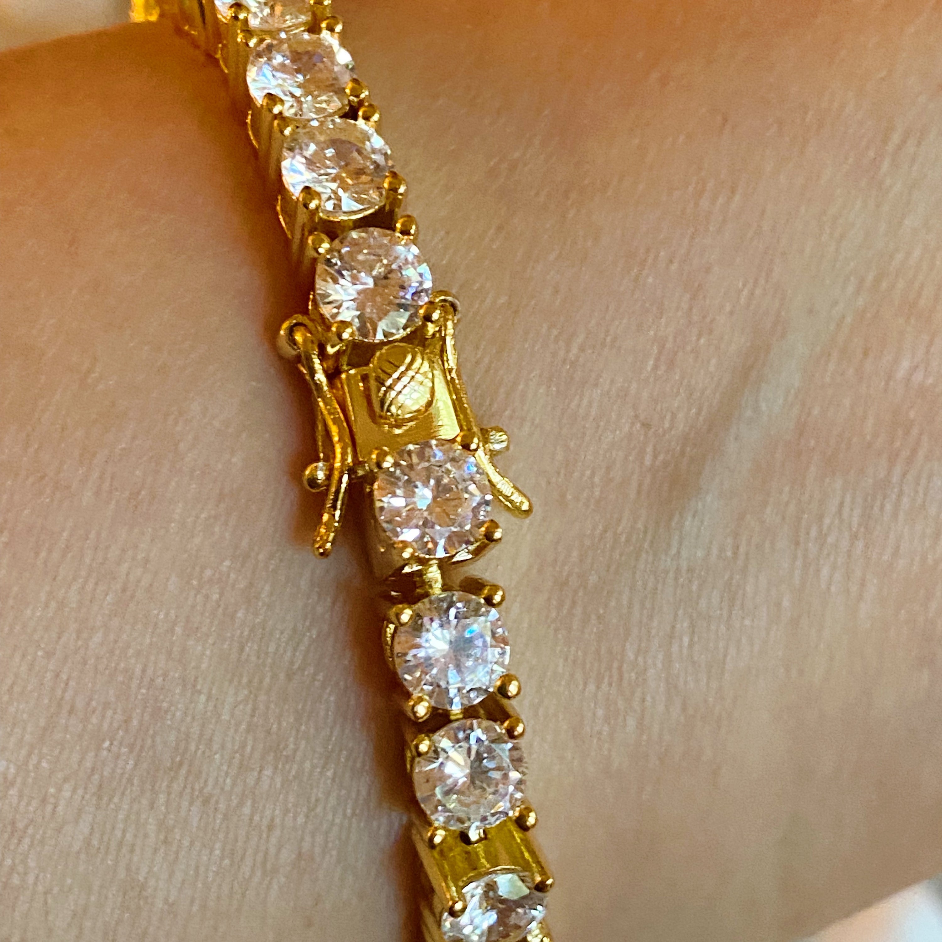 A stunning hand linked high class tennis bracelet featuring AAA grade Cubic Zirconia stones, gold plated brass, and a secure double closure.