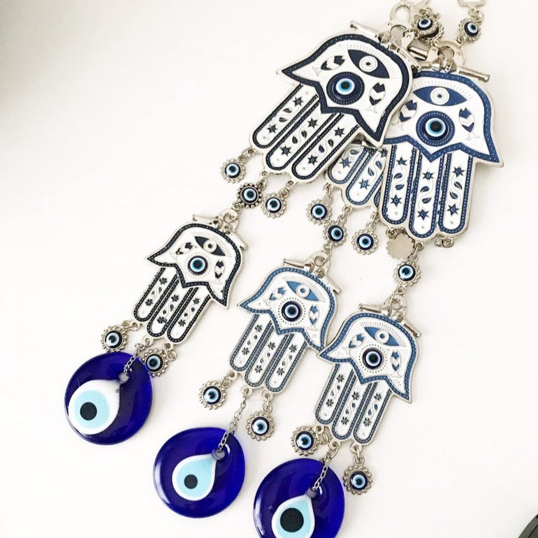 Hand of Fatima wall decor featuring evil eye beads, showcasing intricate metal craftsmanship and vibrant colors.