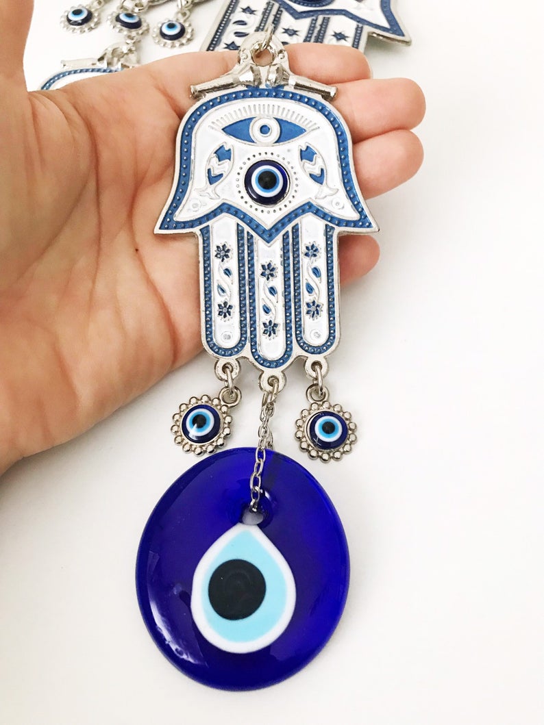 Hand of Fatima wall decor featuring evil eye beads, showcasing intricate metal craftsmanship and vibrant colors.