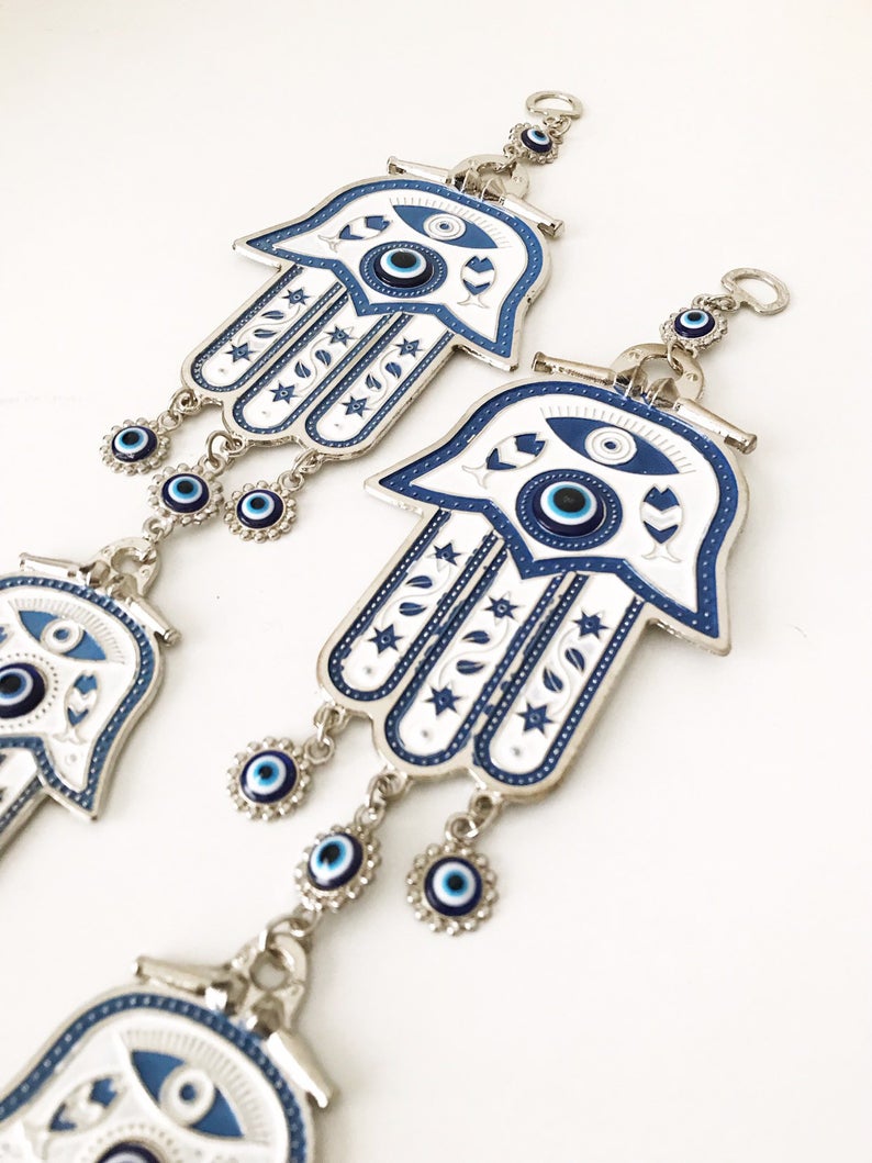 Hand of Fatima wall decor featuring evil eye beads, showcasing intricate metal craftsmanship and vibrant colors.