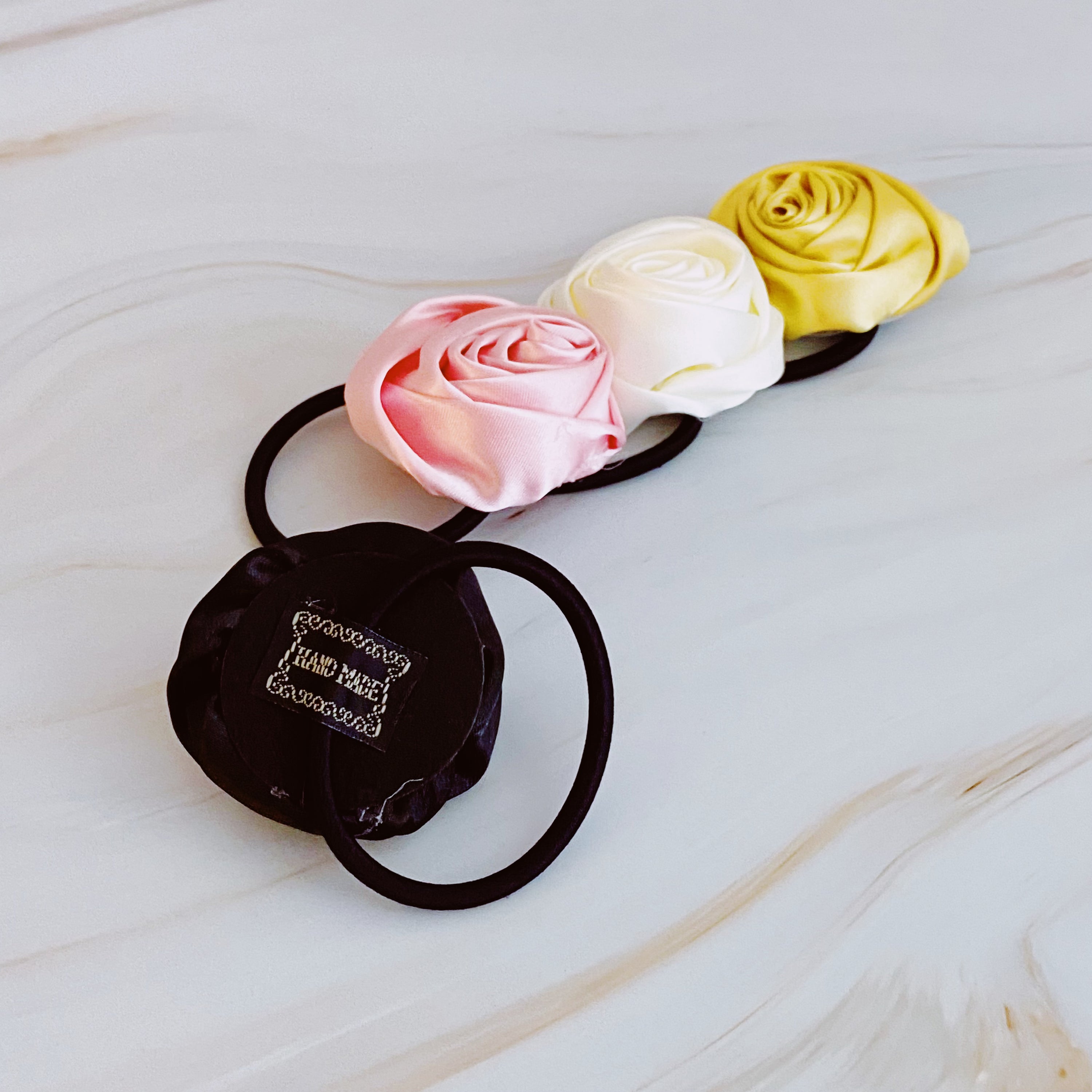 Hand Picked Satin Rose Hair Tie Set of 4 in neutral colors, featuring elegant rose-shaped designs.