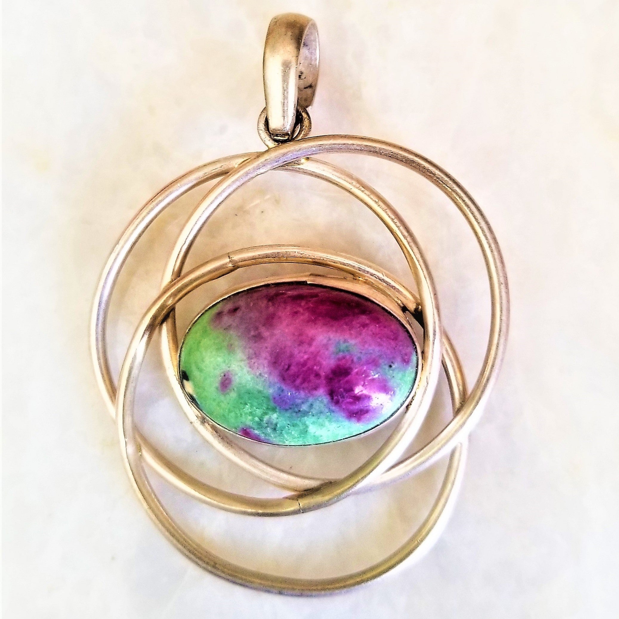 Hand wrapped silver pendant featuring natural Ruby Zoisite, showcasing vibrant red and green colors, handcrafted by Indian artisans.