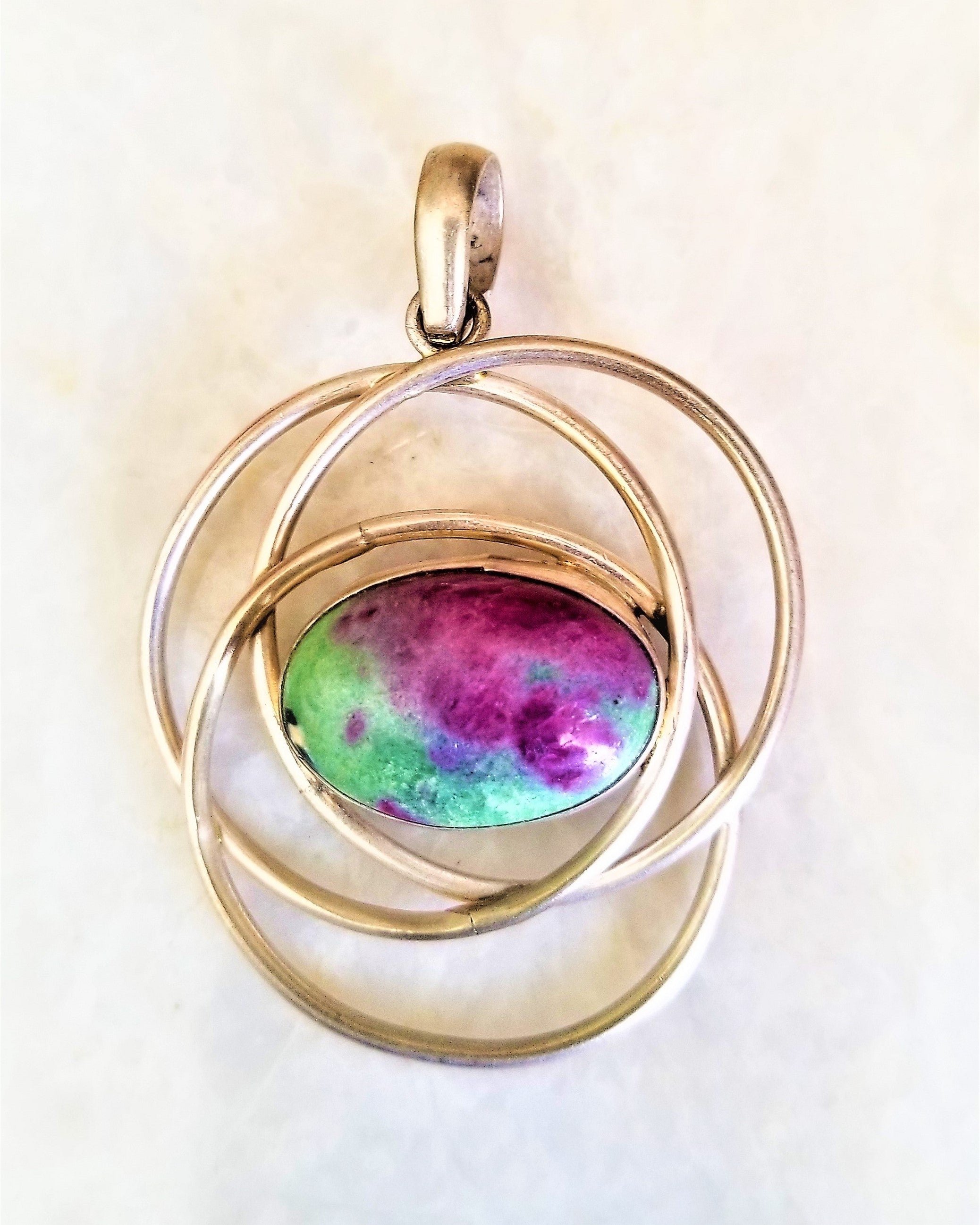 Hand wrapped silver pendant featuring natural Ruby Zoisite, showcasing vibrant red and green colors, handcrafted by Indian artisans.