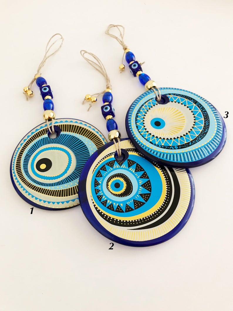 A beautifully crafted Handmade Evil Eye Wall Hanging featuring a large 13cm evil eye bead, showcasing intricate designs and vibrant colors.